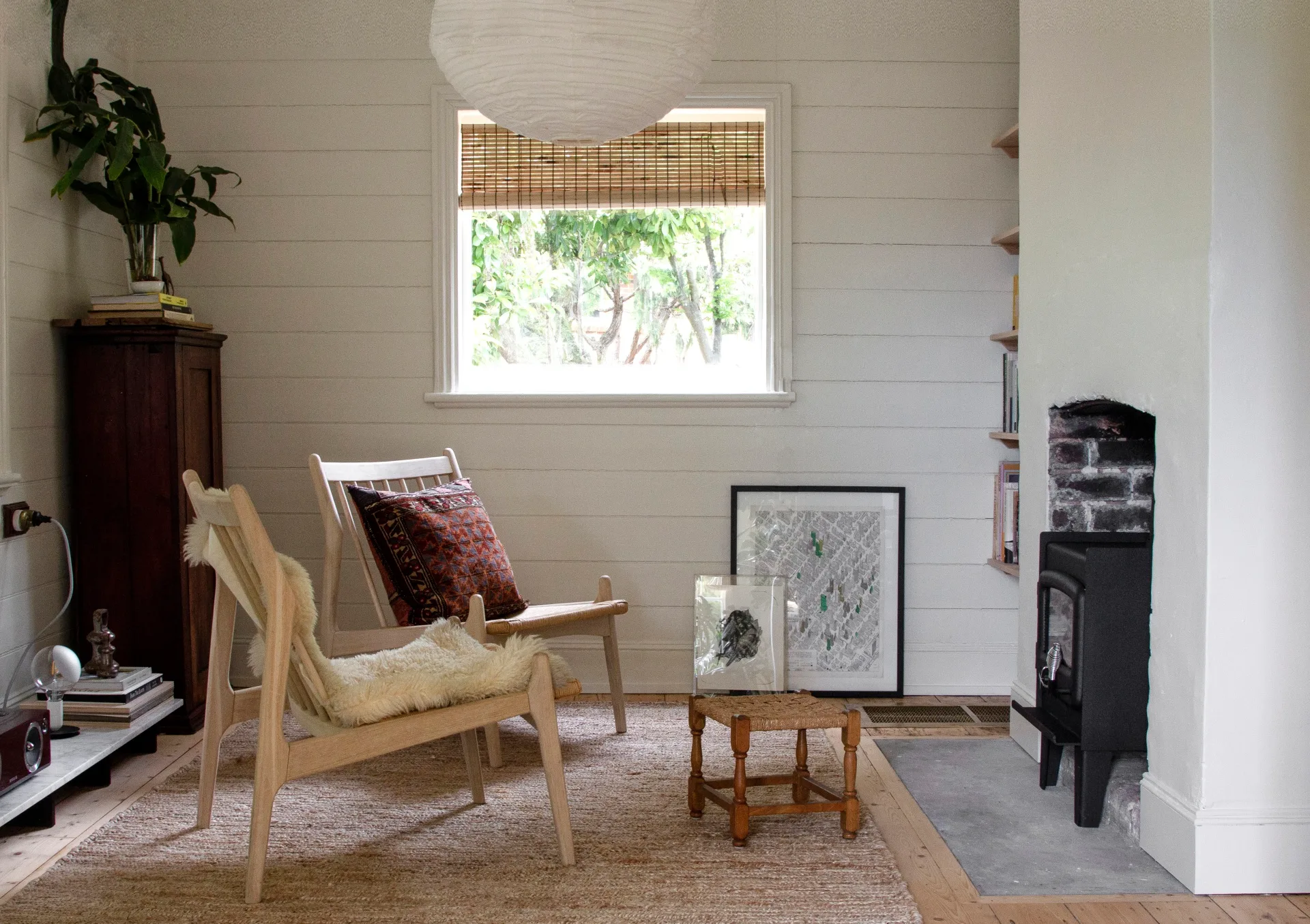 A small sitting room with a fireplace and jute rug