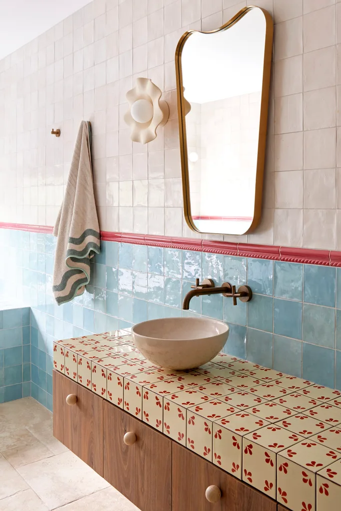 A colourful bathroom with blue tiles and timber cabinetry