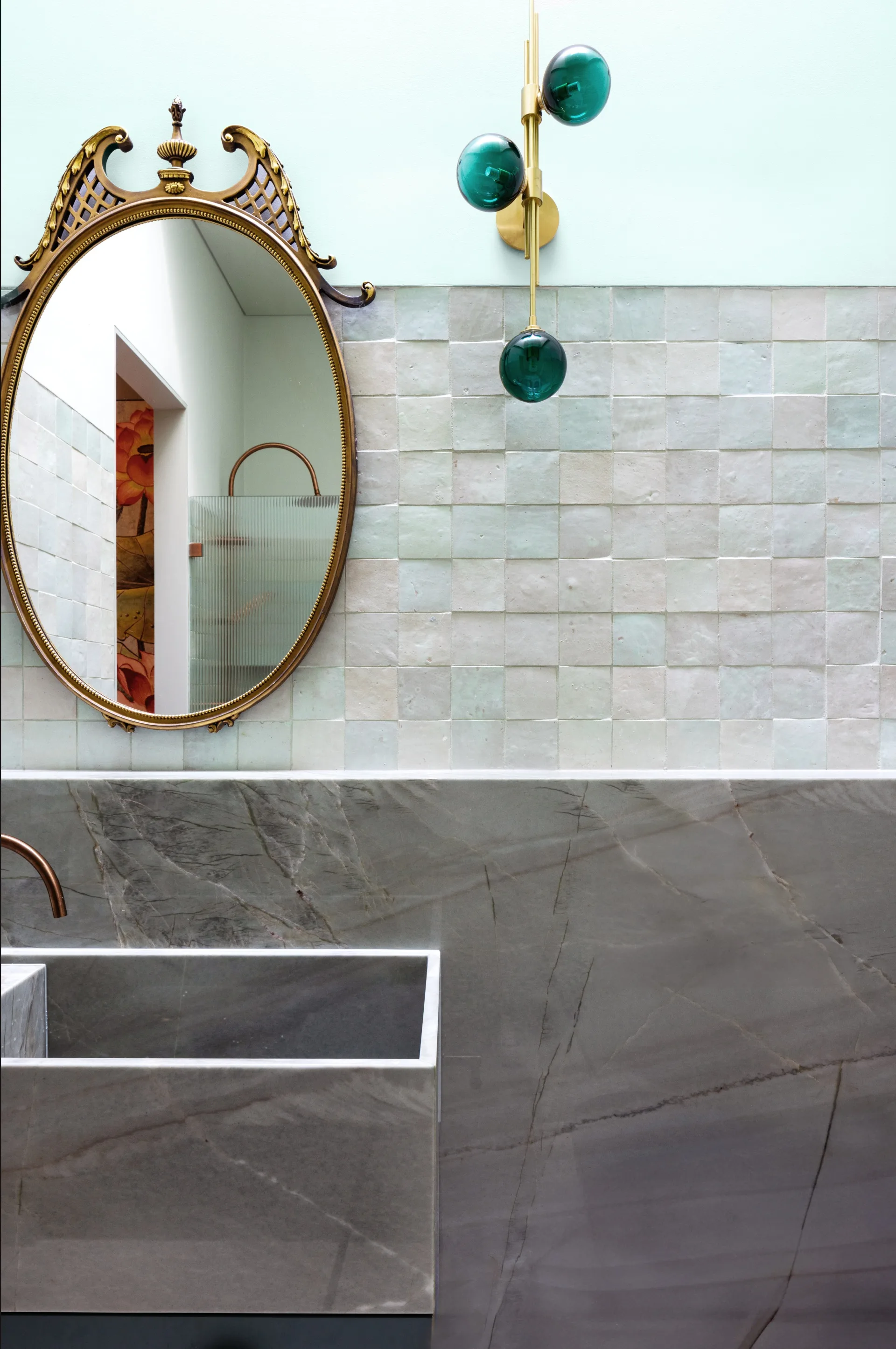 A marble powder room with a gilt mirror