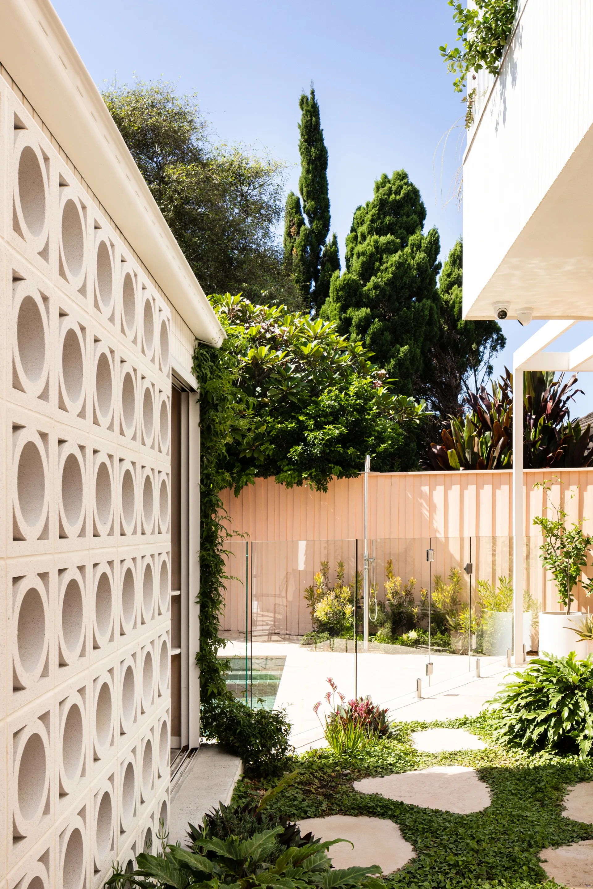 A garden with stepping stones and a breezeblock wall
