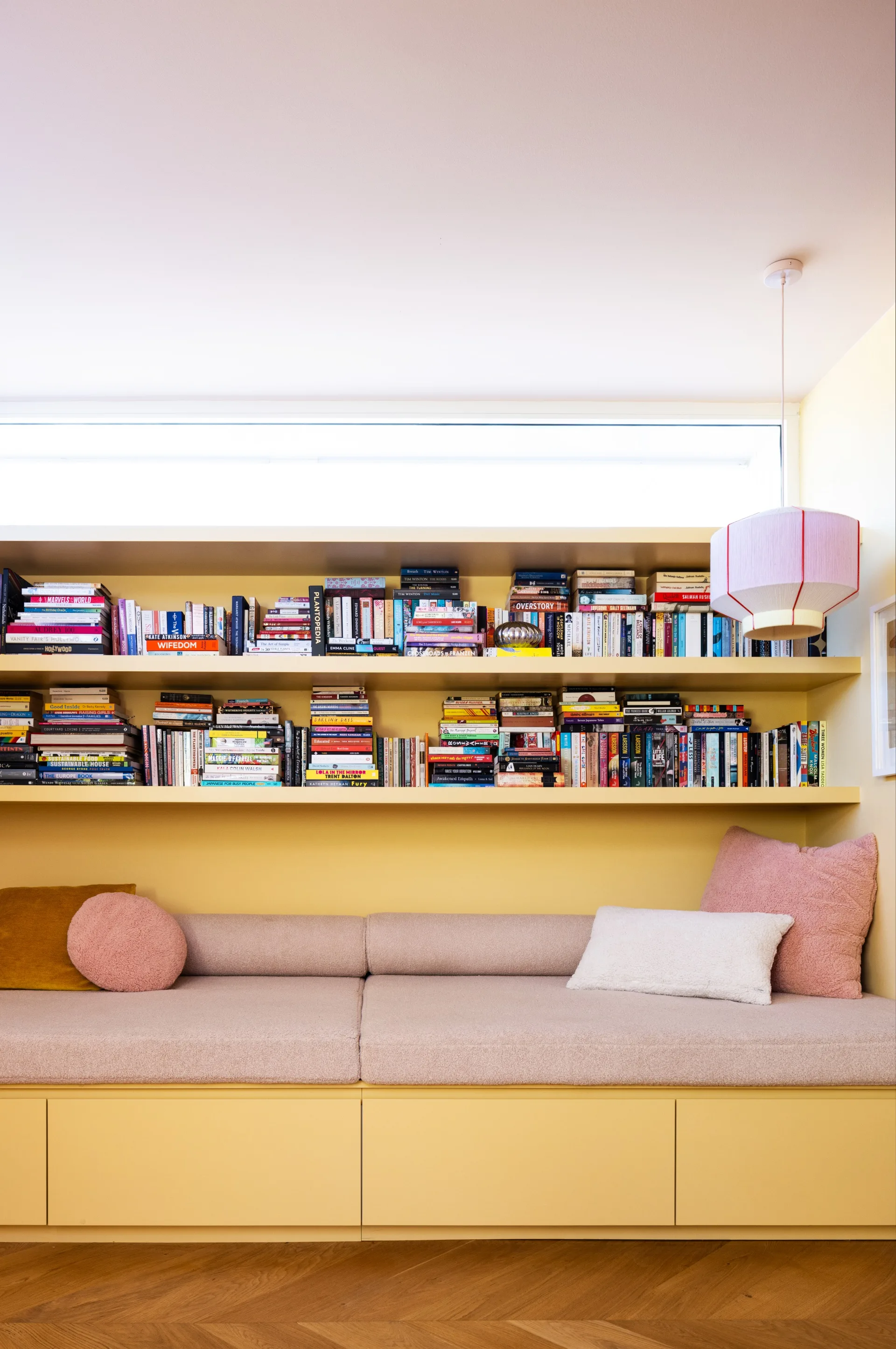 A yellow library wall with an in-built seat