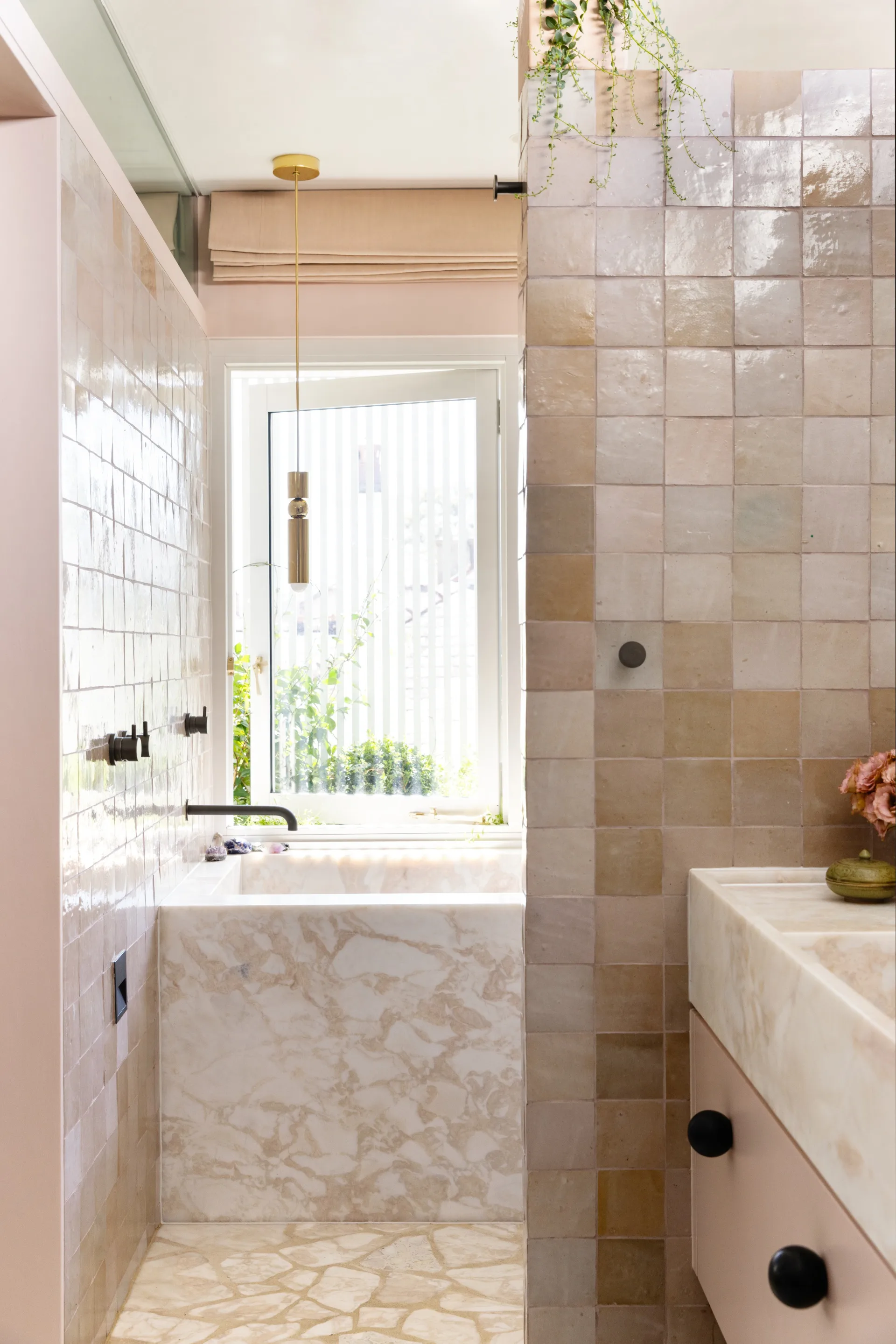 A marble and pastel pink tiled bathroom