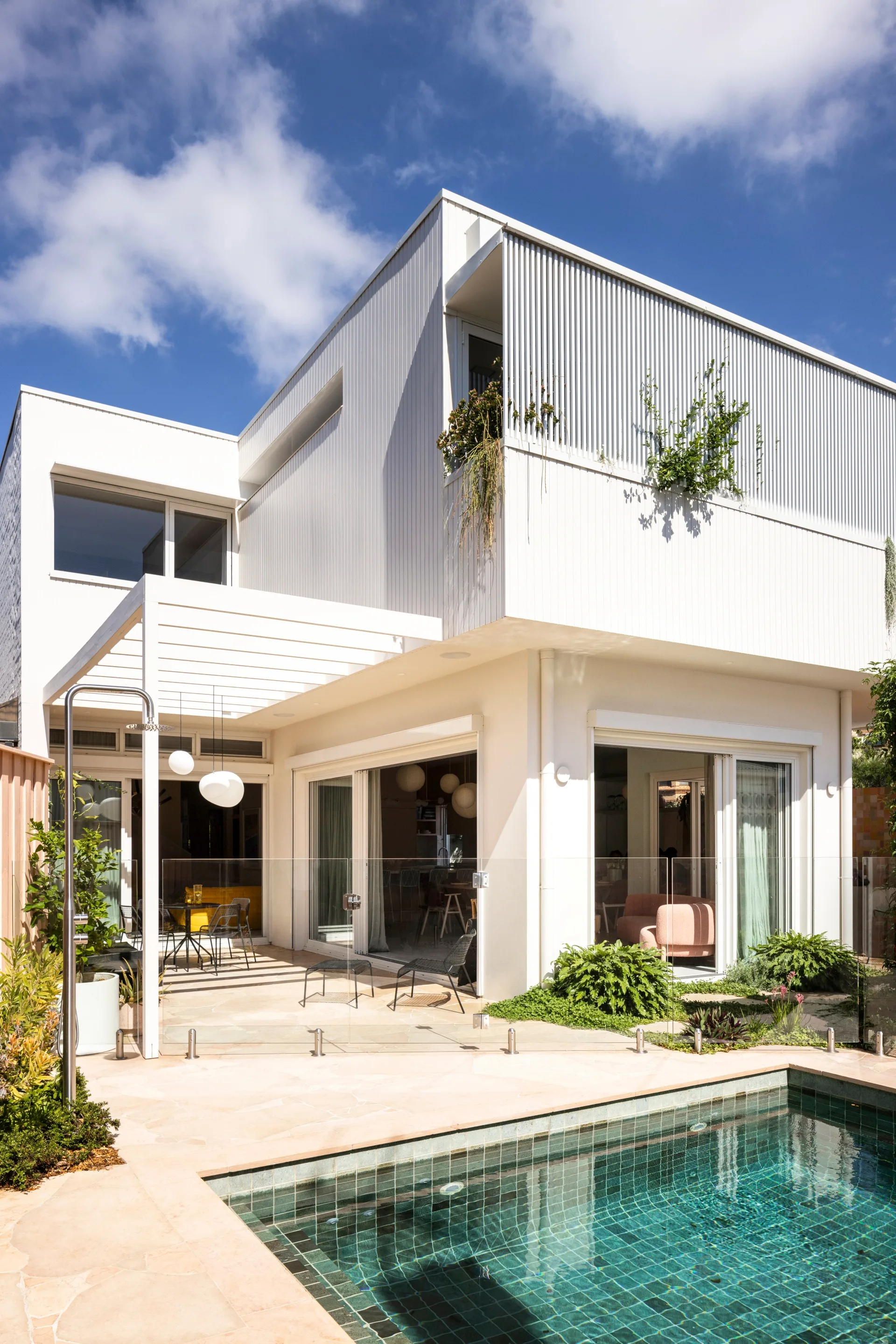 A modern white double storey home with a swimming pool