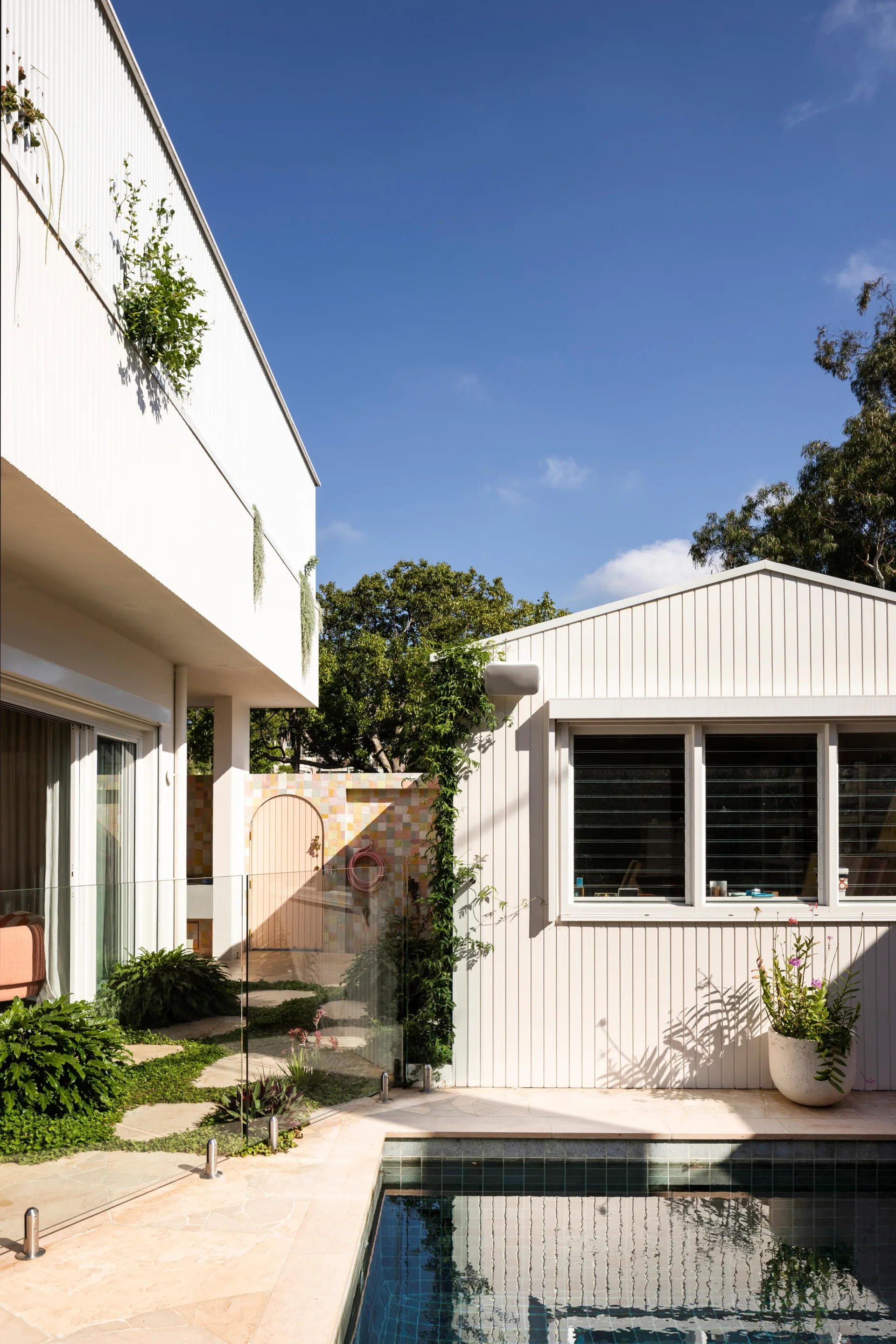 A swimming pool with a weatherboard pool house