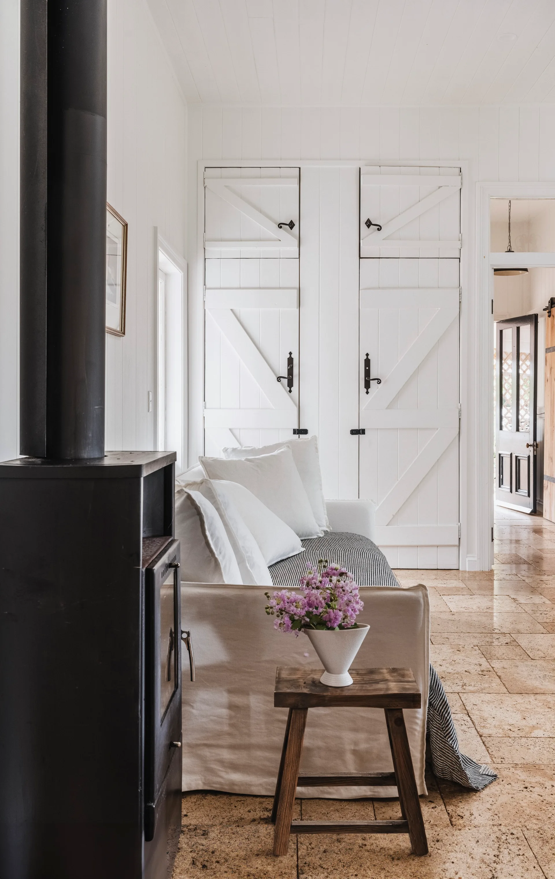 sofa by a black wood burning fireplace