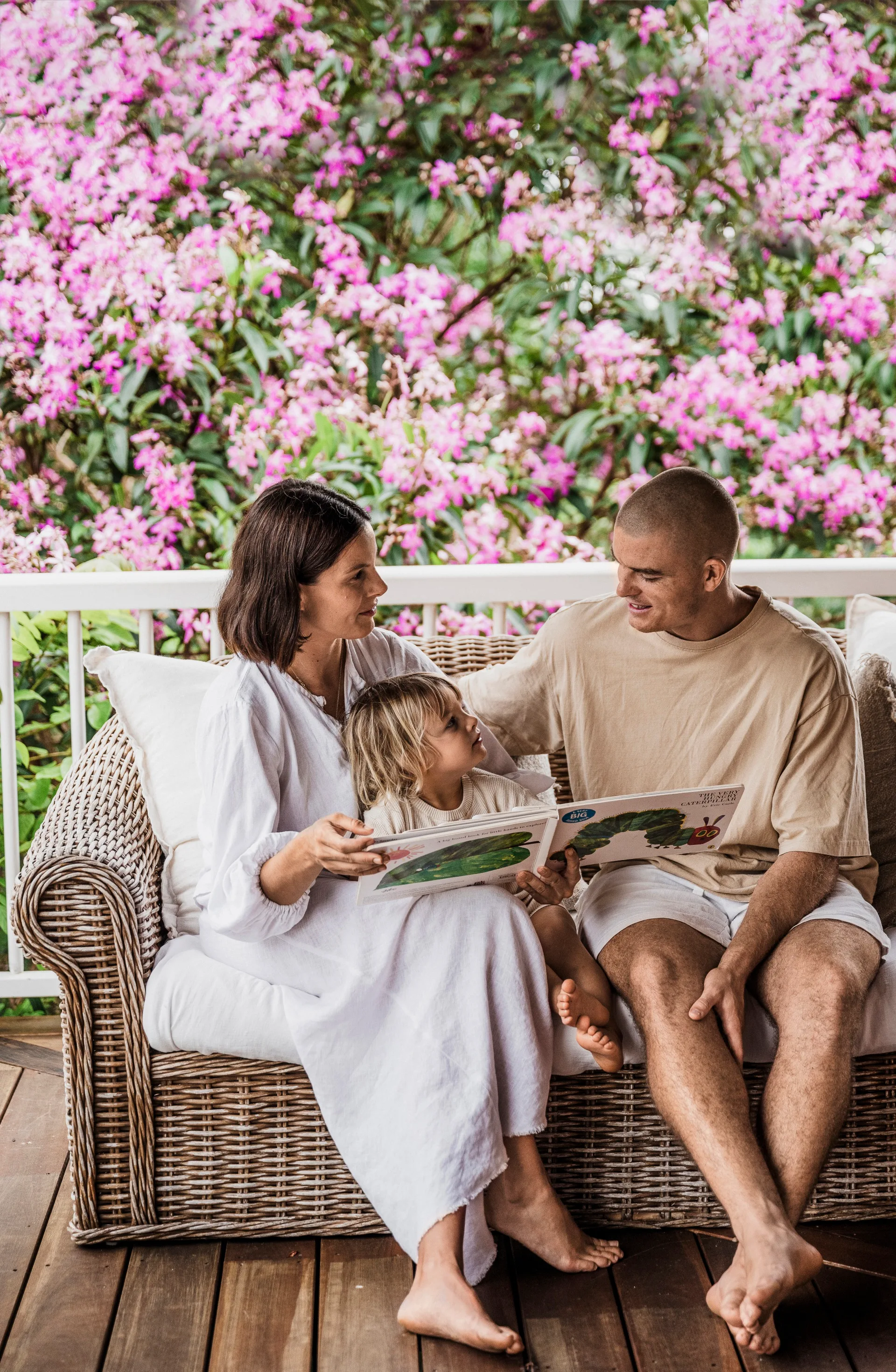 couple reading book to their child