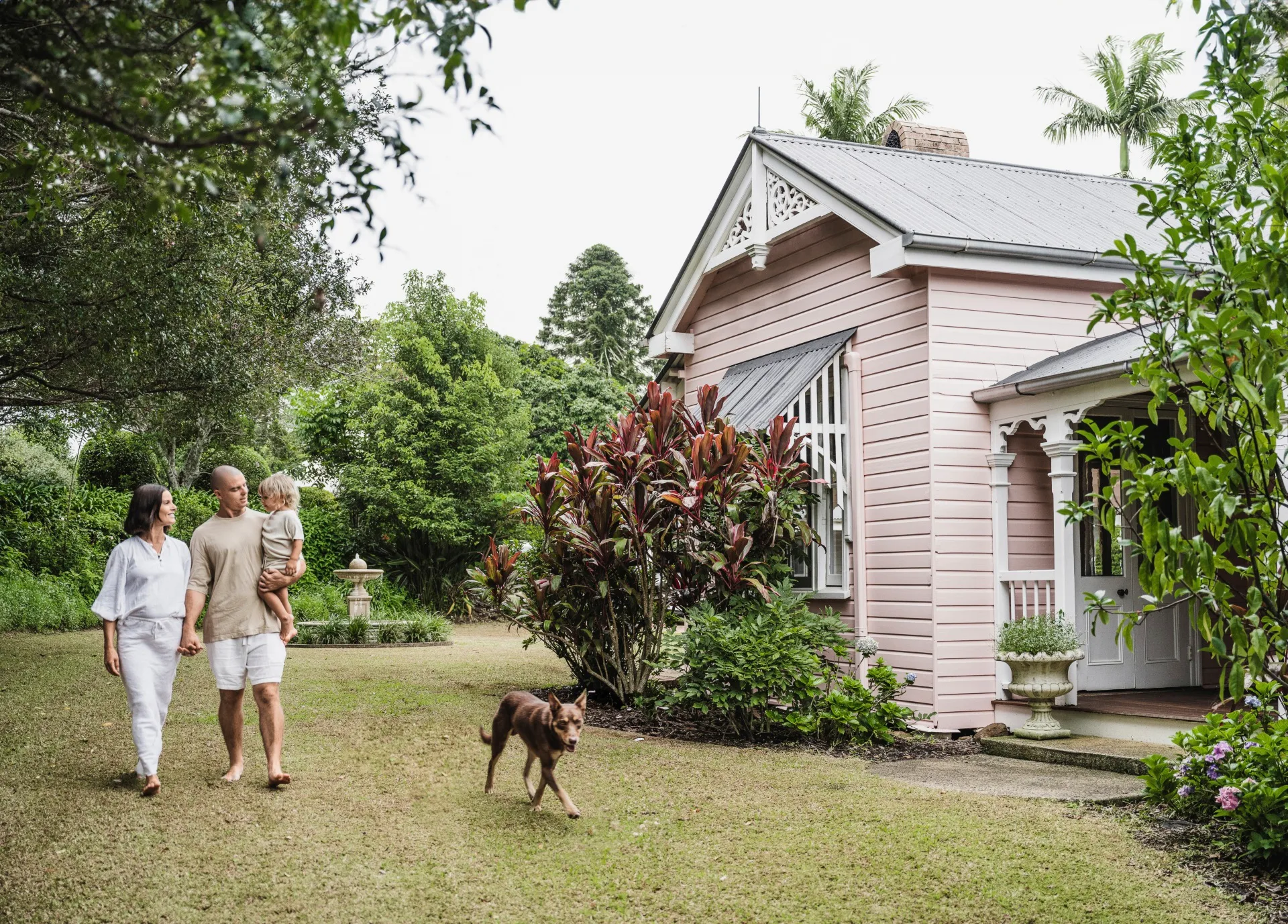 couple walking in the garden with child and dog
