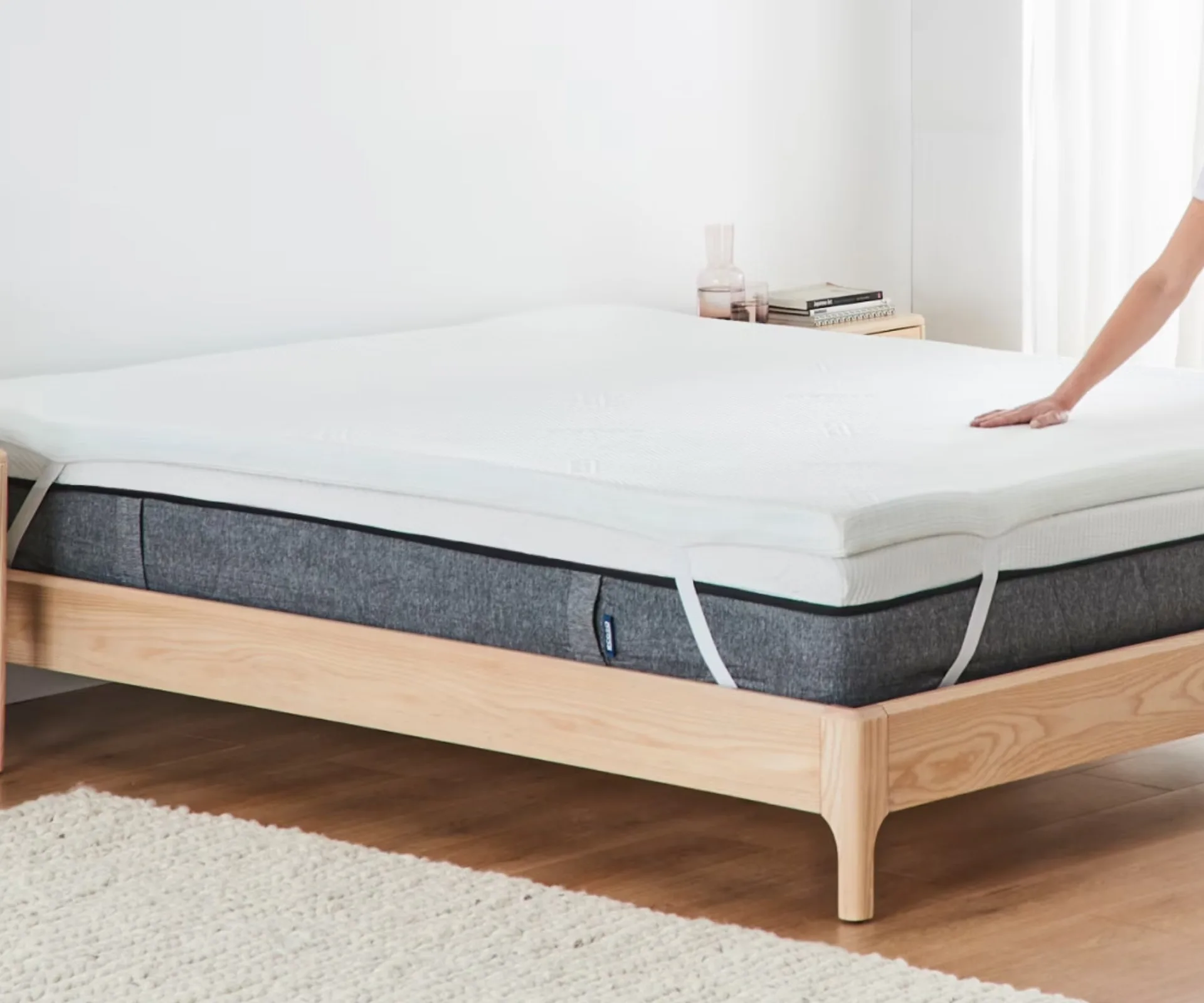 A mattress and mattress topper on a timber bed frame all from Ecosa