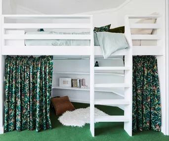 A white loft bed in a bedroom with green carpet