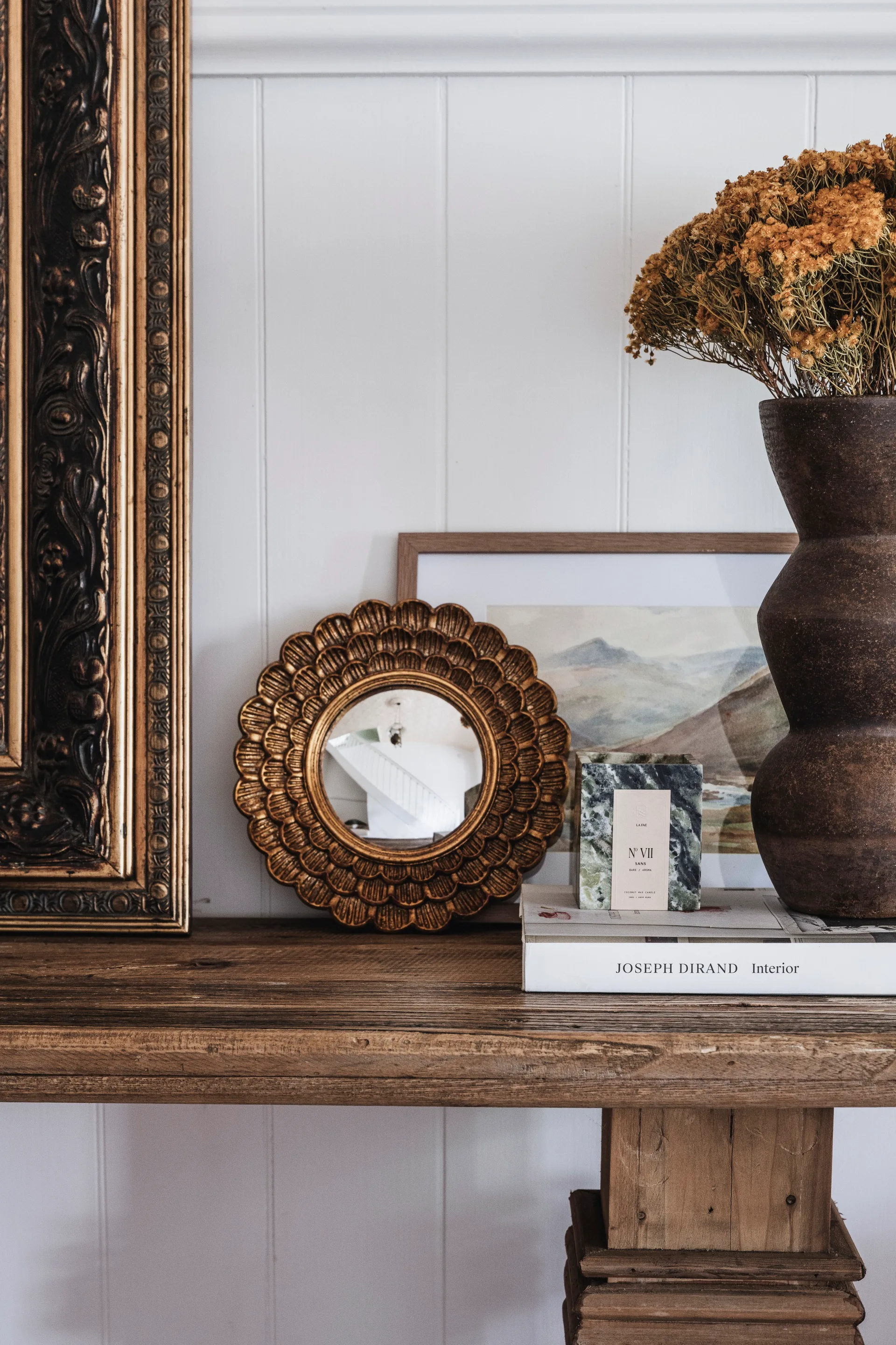 styled shelf with small gold mirror