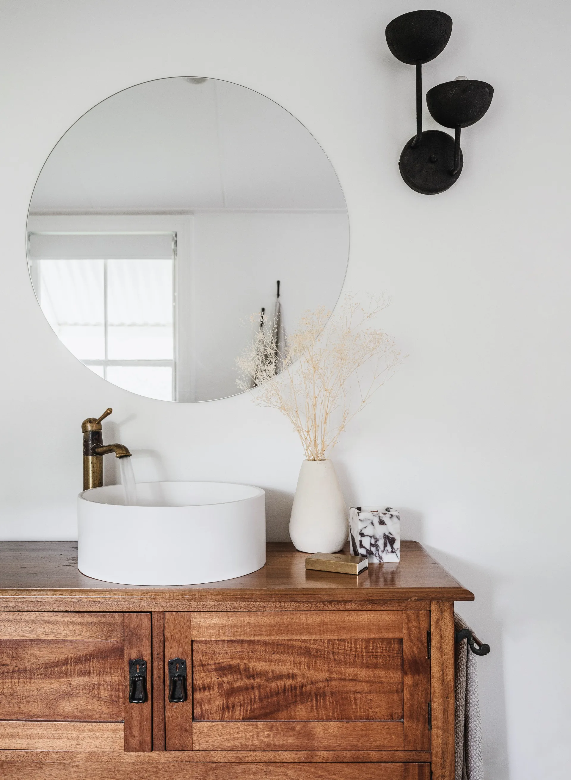 timber bathroom vanity with circular mirror
