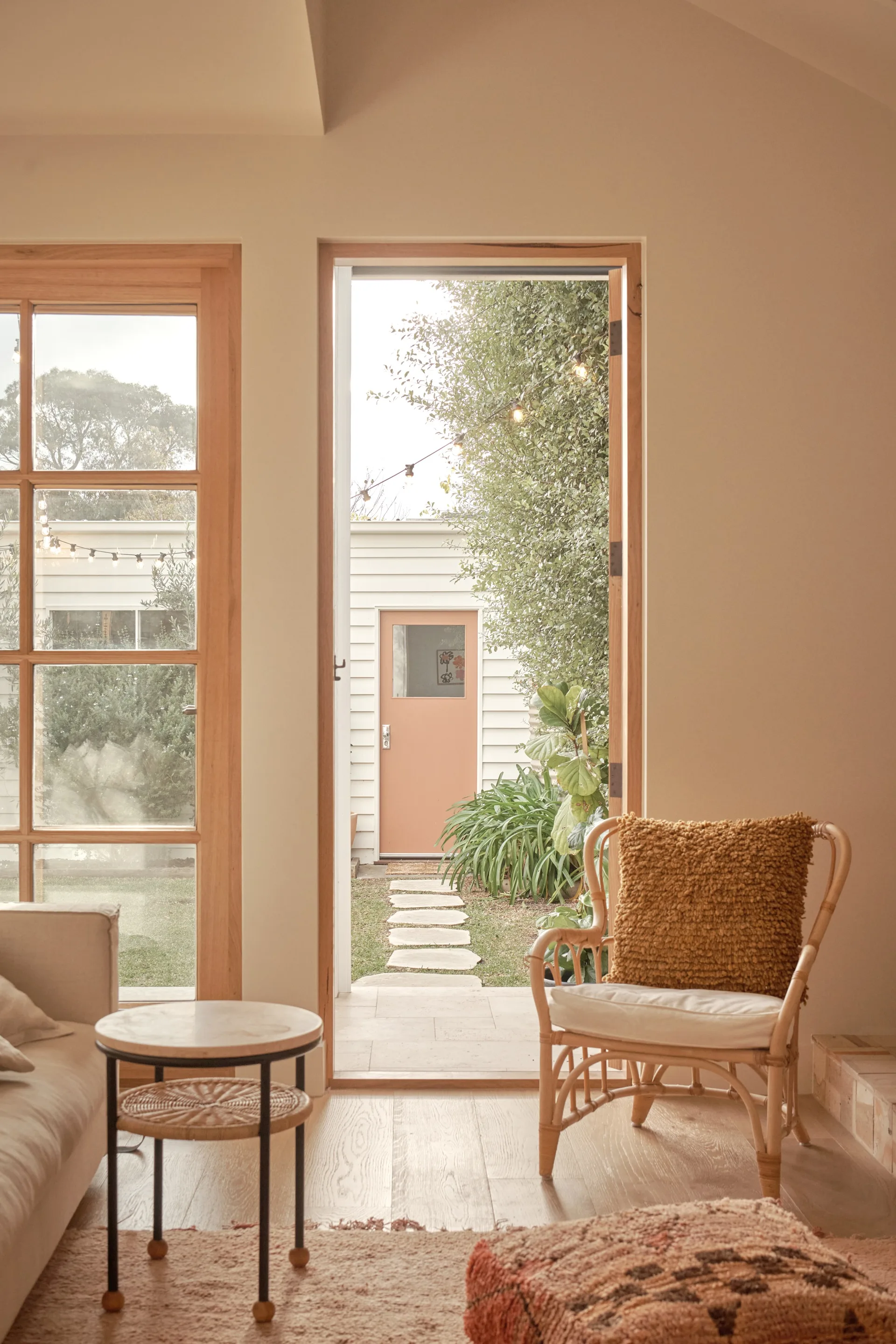 A rattan armchair and view out to a garden