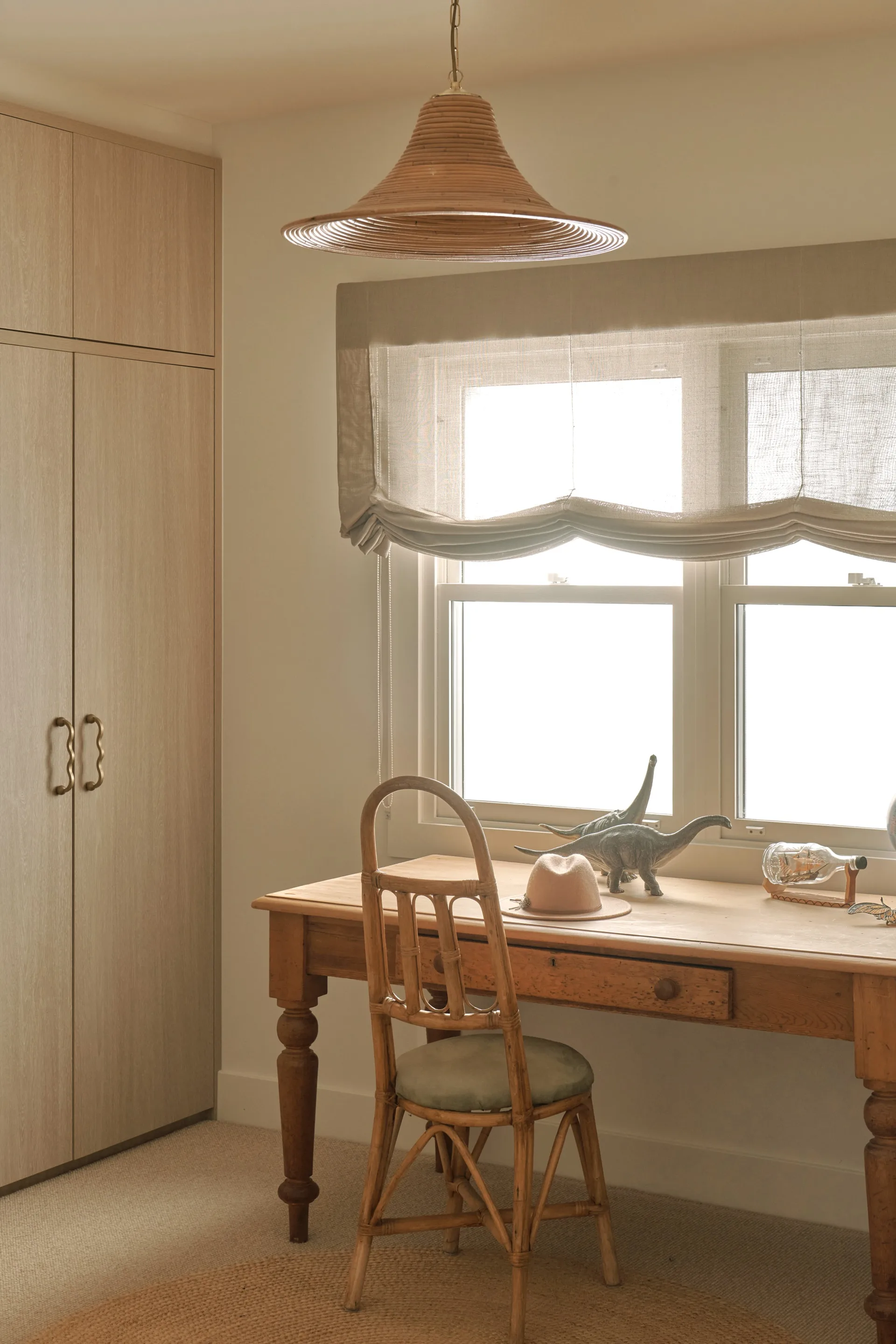 An antique desk with toy dinosaurs in a children's bedroom,