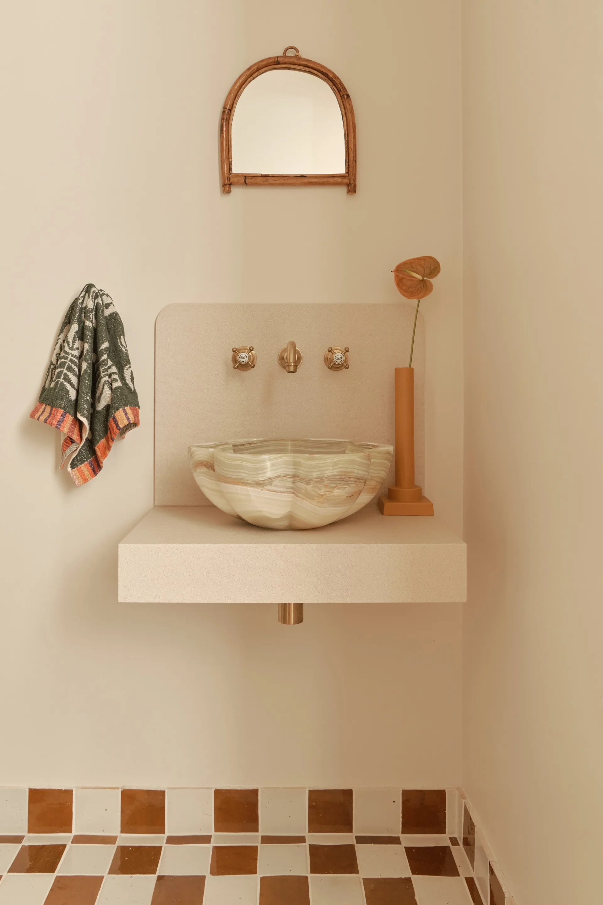 An ensuite bathroom with a marble-toned curved vessel sink