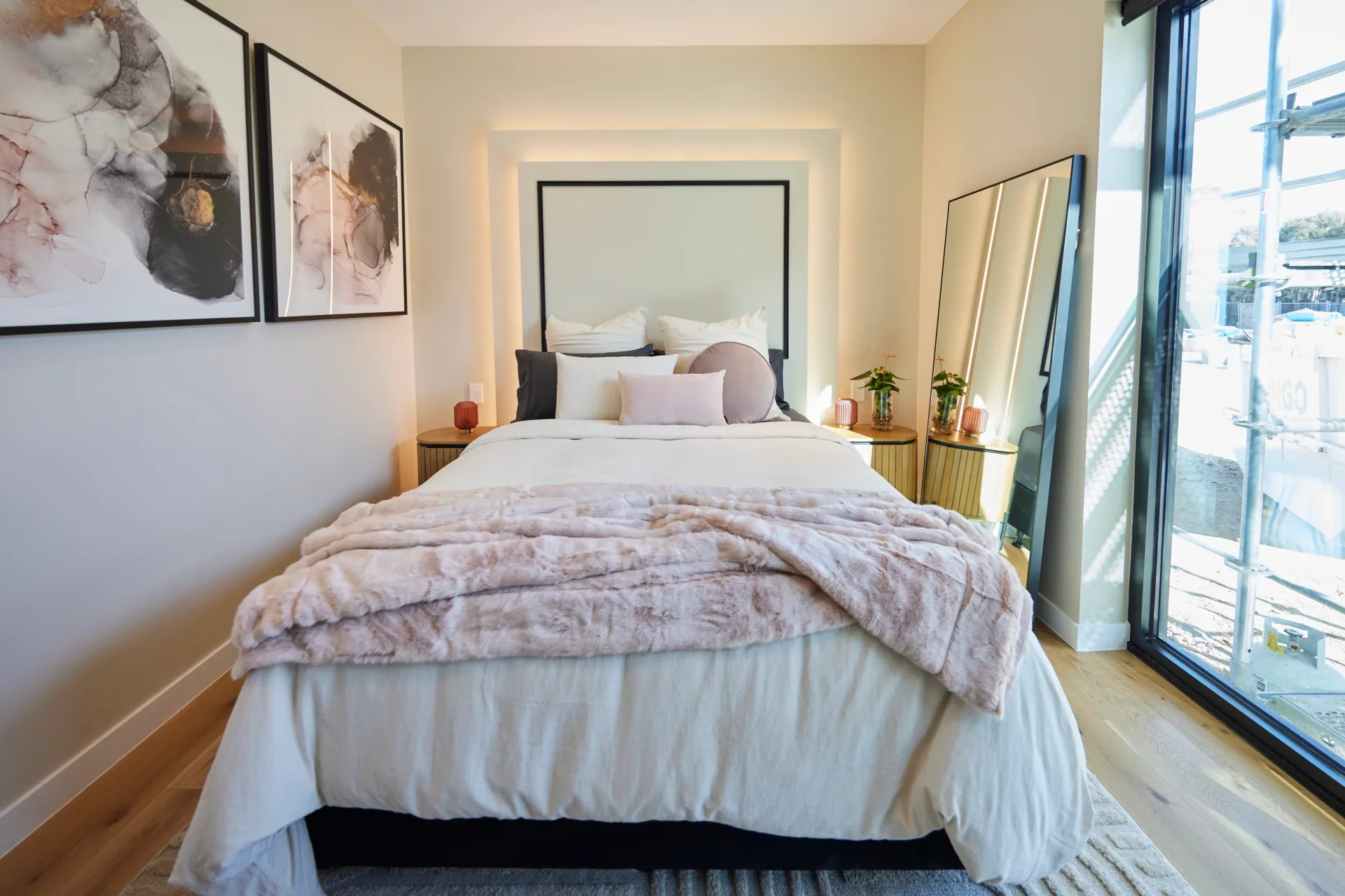 A monochromatic bedroom with pops of pastel pink 