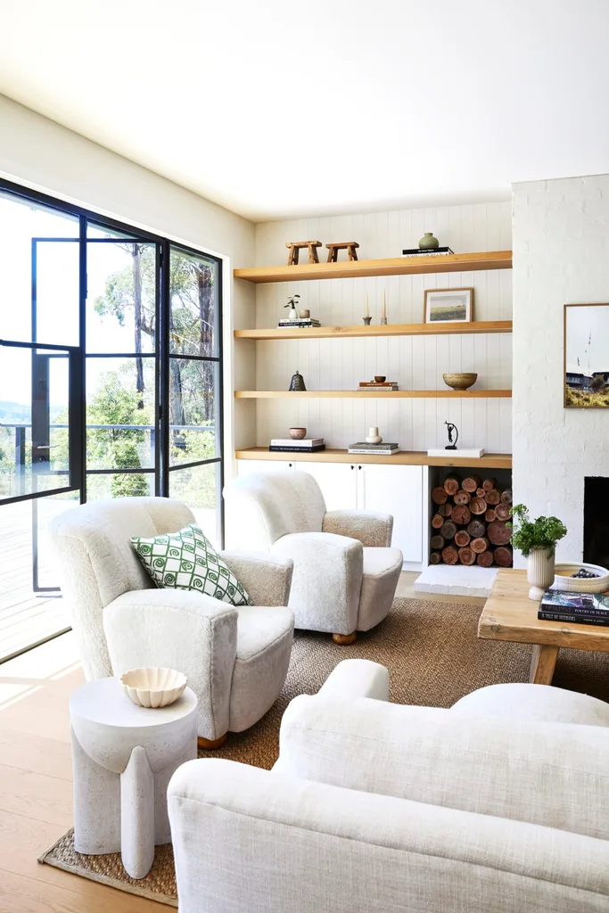 A modern country-inspired living room with a fireplace and white chairs