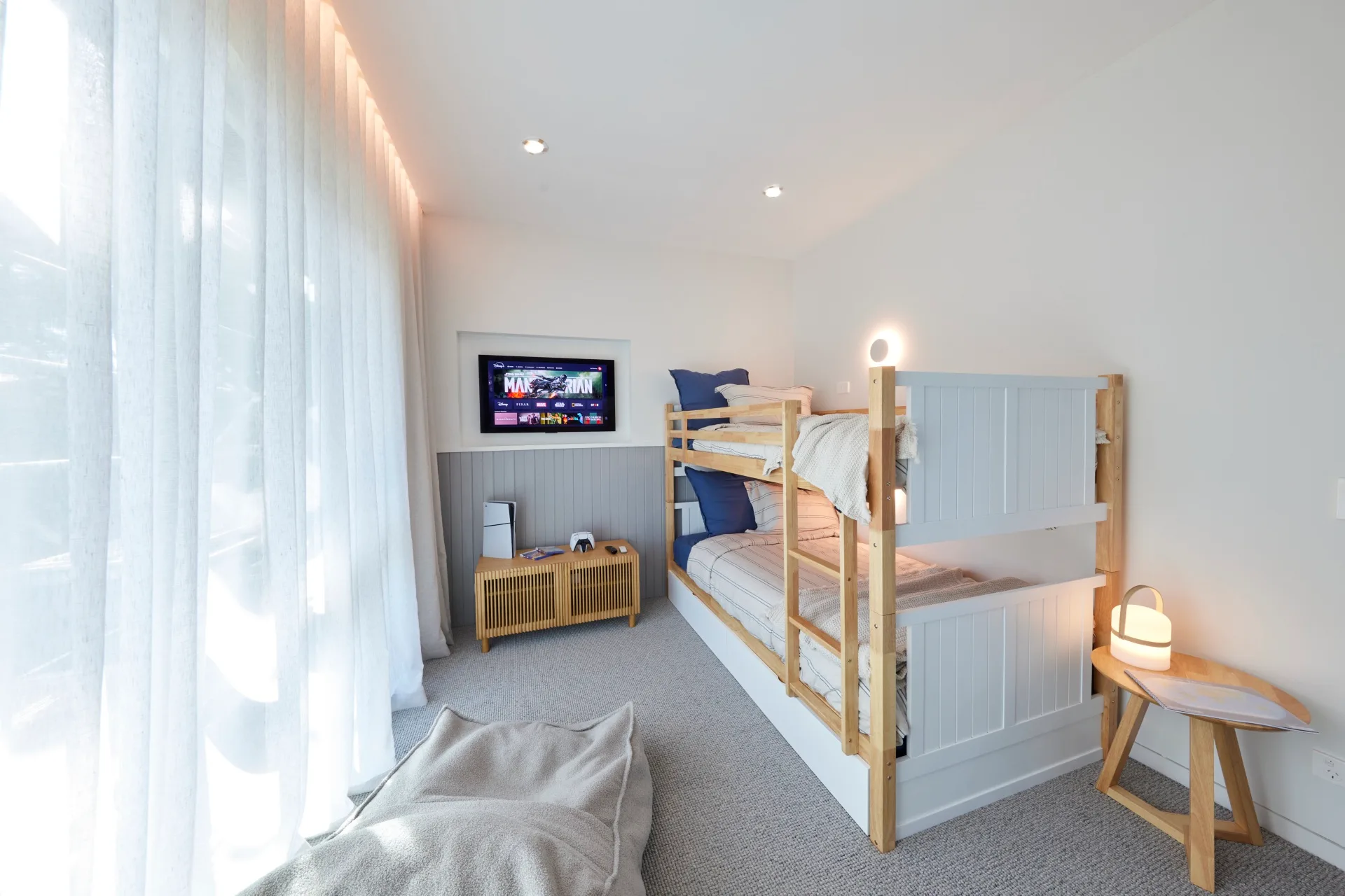A kids bedroom with a bunk bed and rattan side board