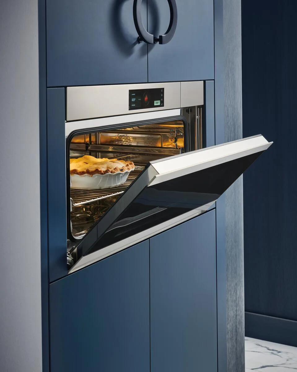 a steam convection oven built into blue cabinetry
