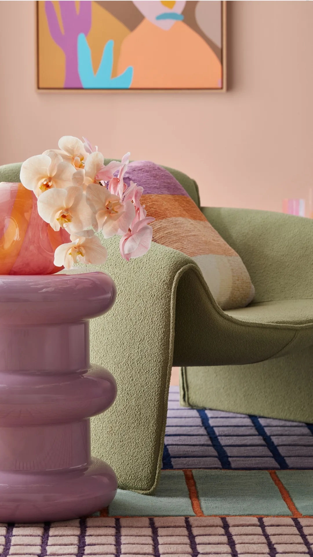 Green boucle chair against a light pink paint backdrop