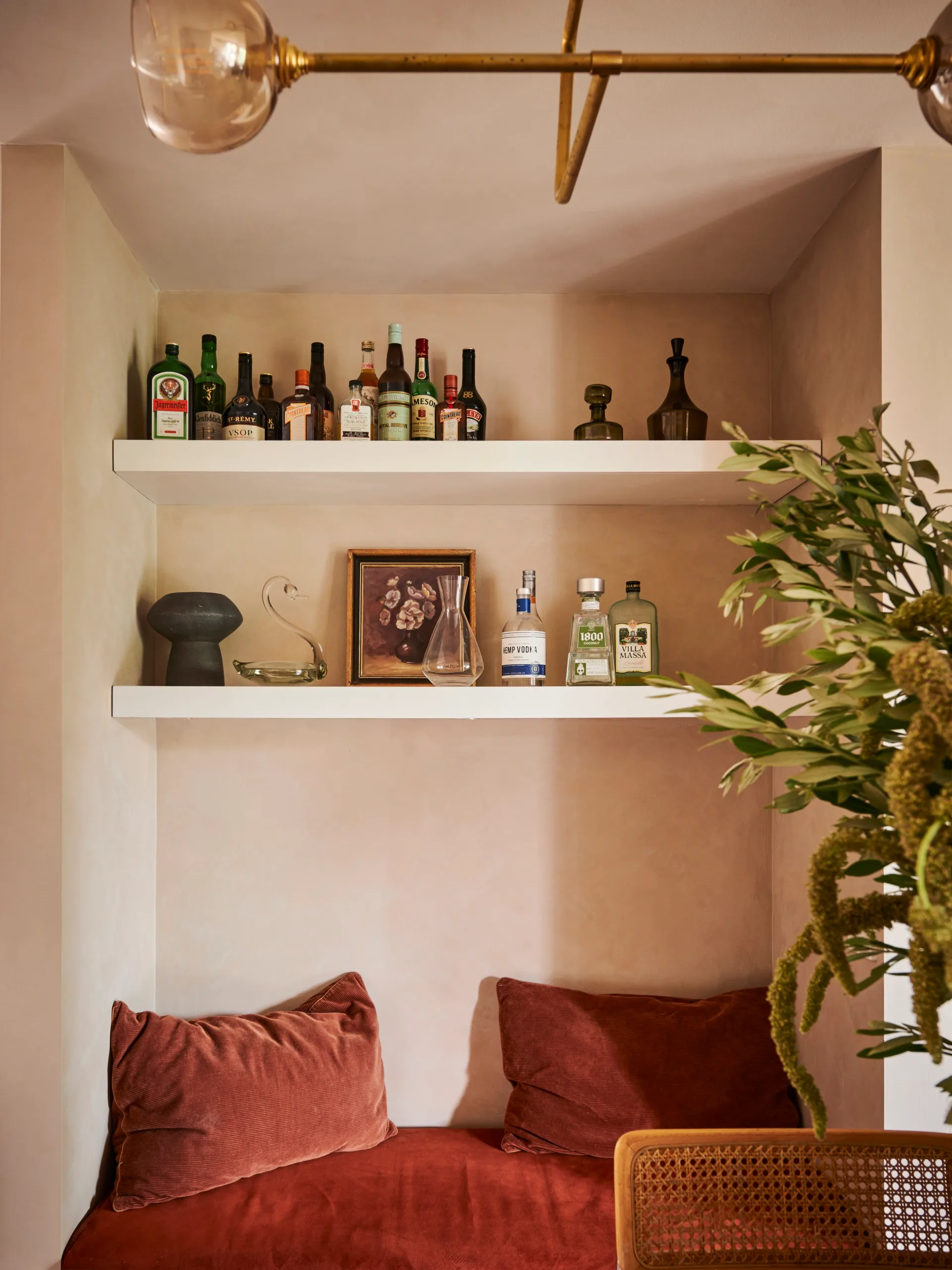 A rust-coloured seating nook under open shelving.