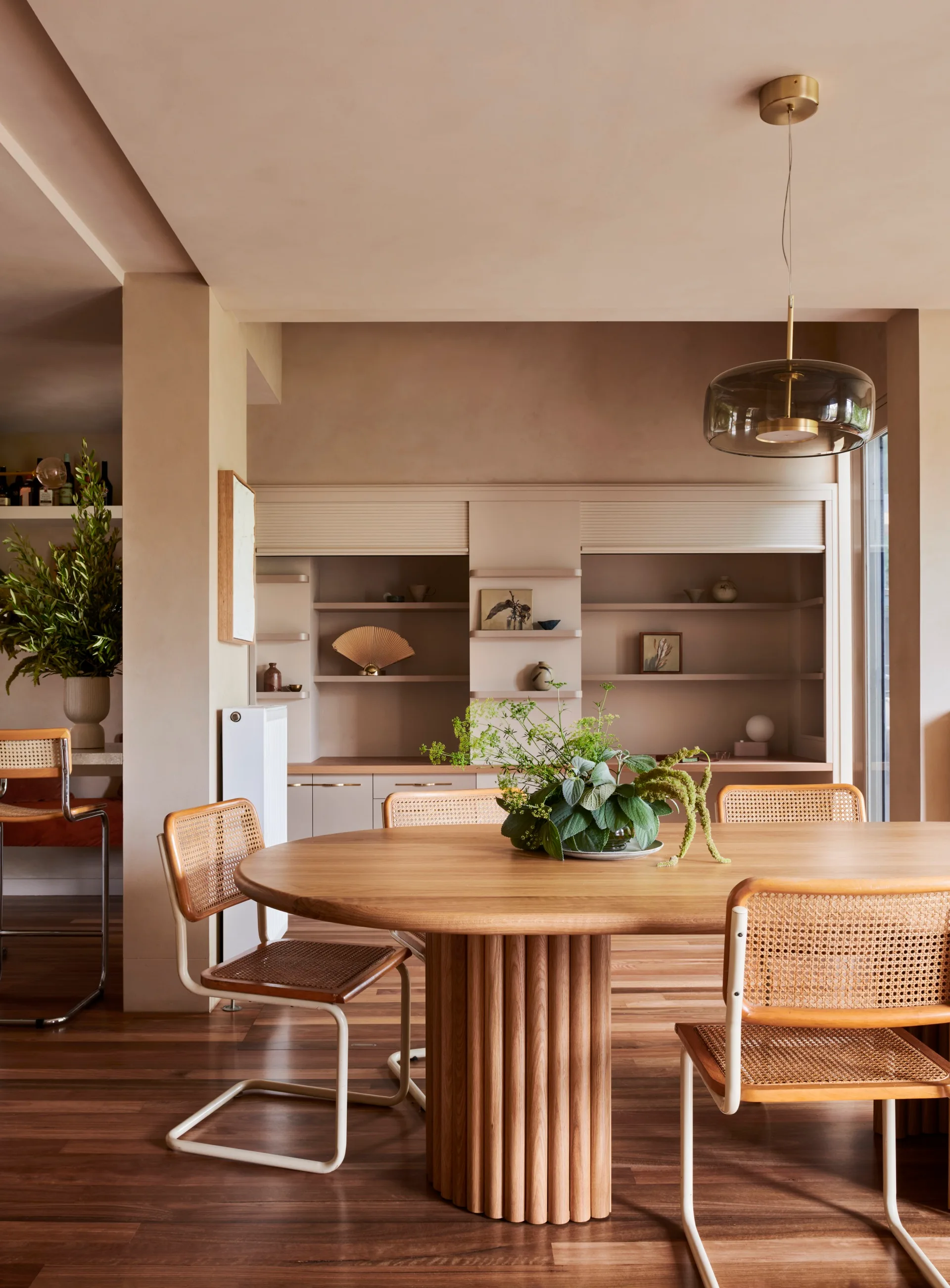 A warm toned dining room with oak dining table and vintage chairs. 