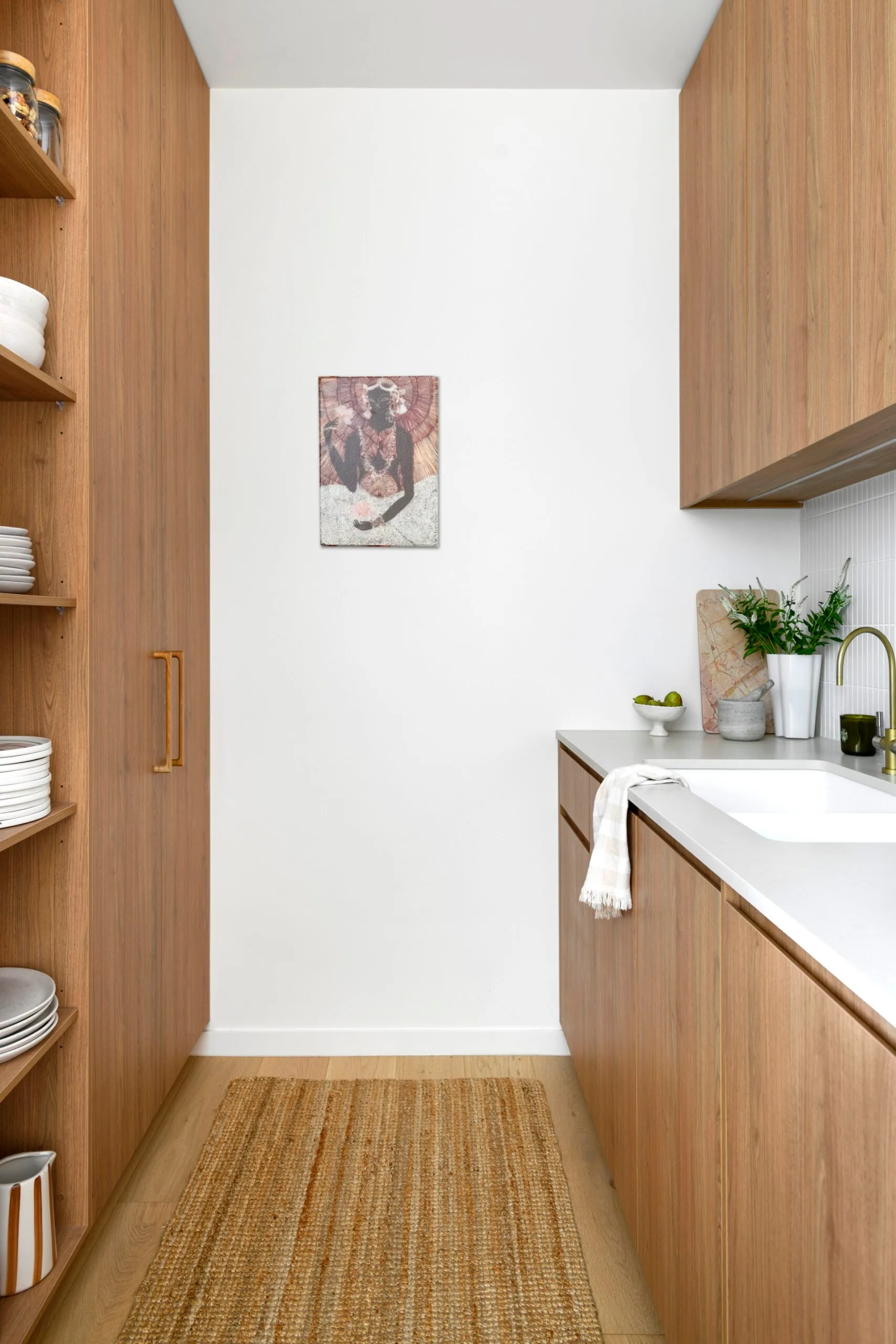 A butler's pantry with timber cabinetry and a jute runner
