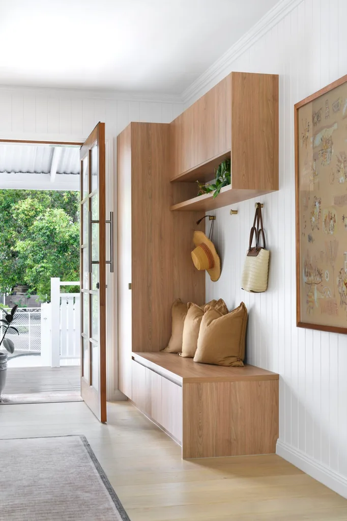 A light-filled entry hall with built-in seating and timber-panelled walls
