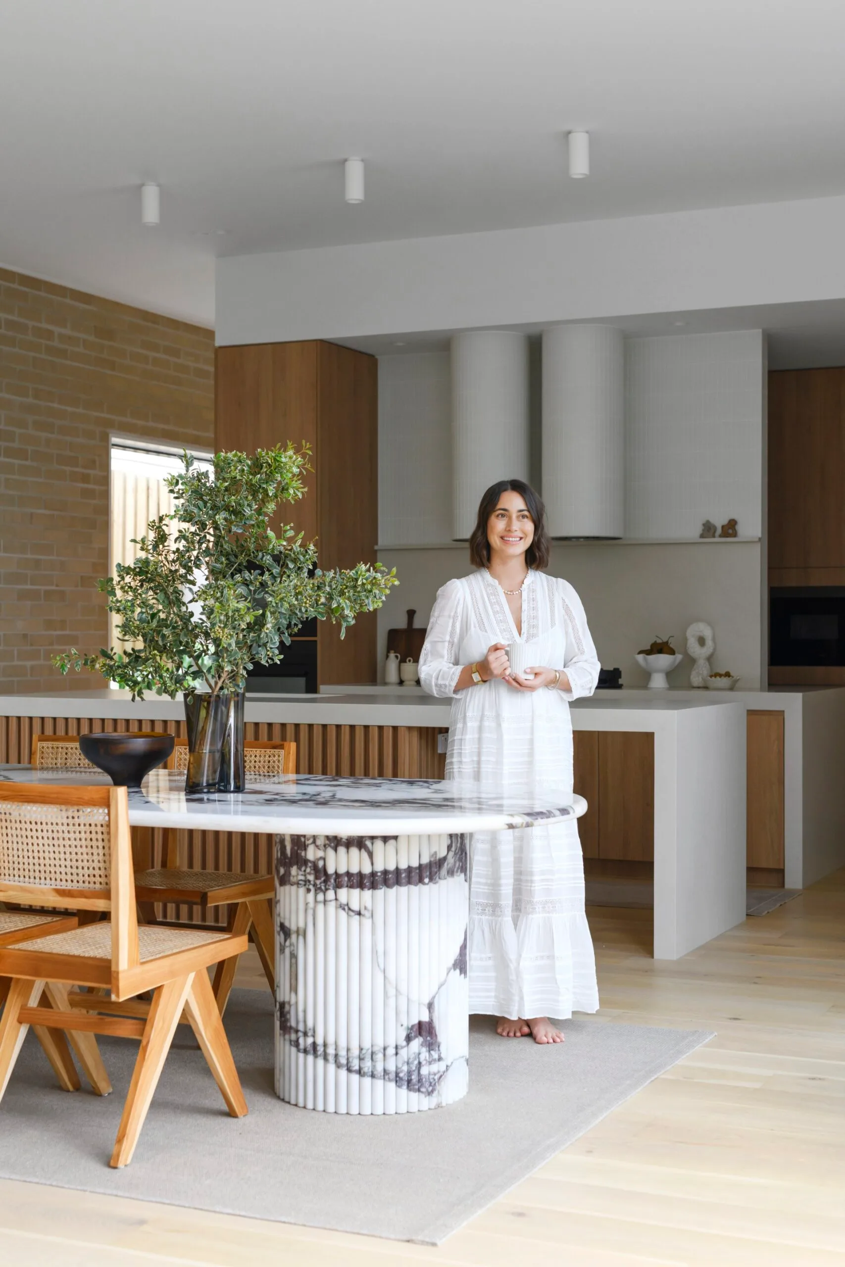 Homeowner Leah standing in her neutral-toned dining area