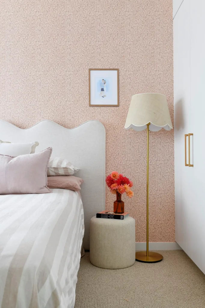 A pink-toned bedroom with striped bedding