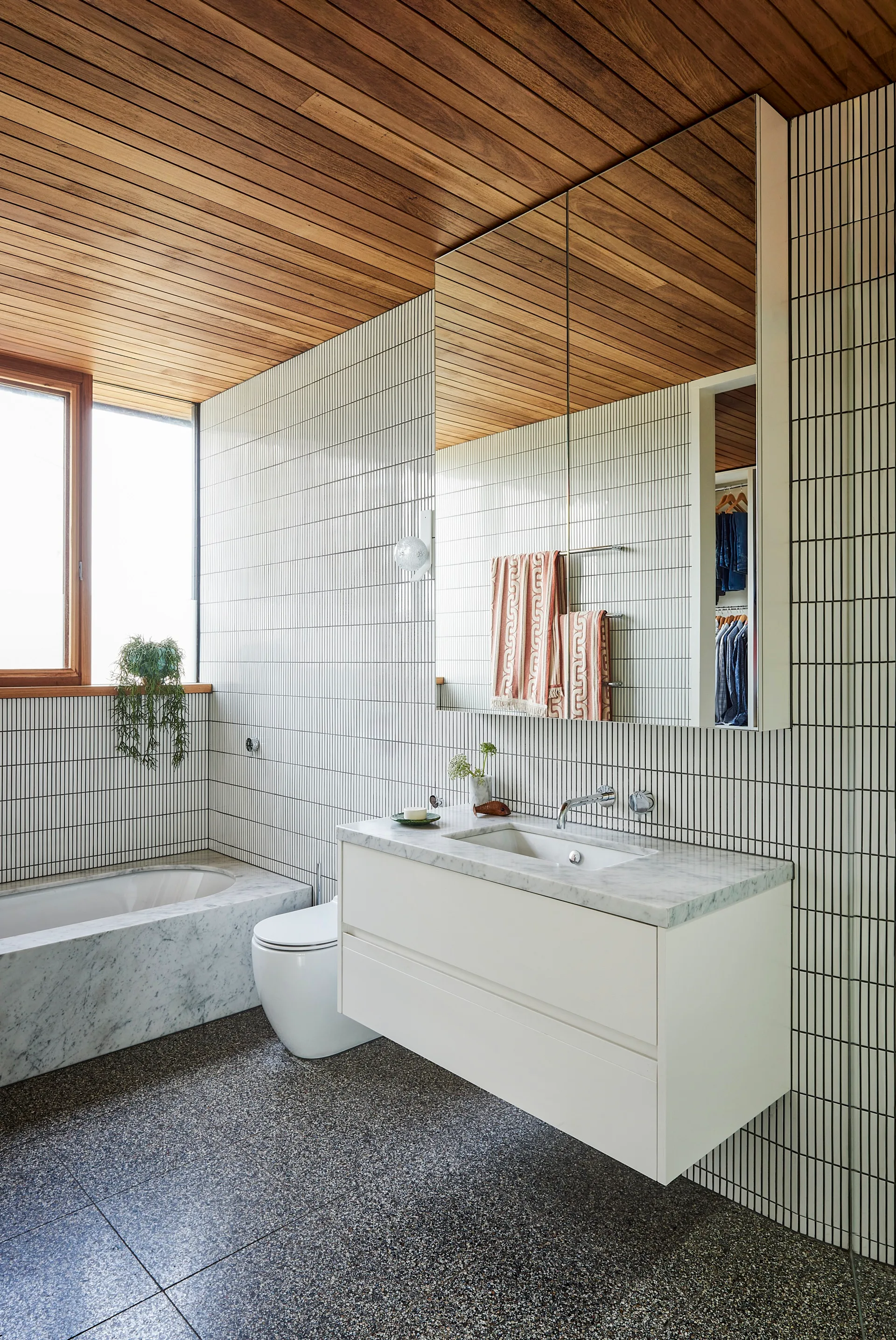 A kit kat-tiled bathroom with terrazzo flooring and marble countertops