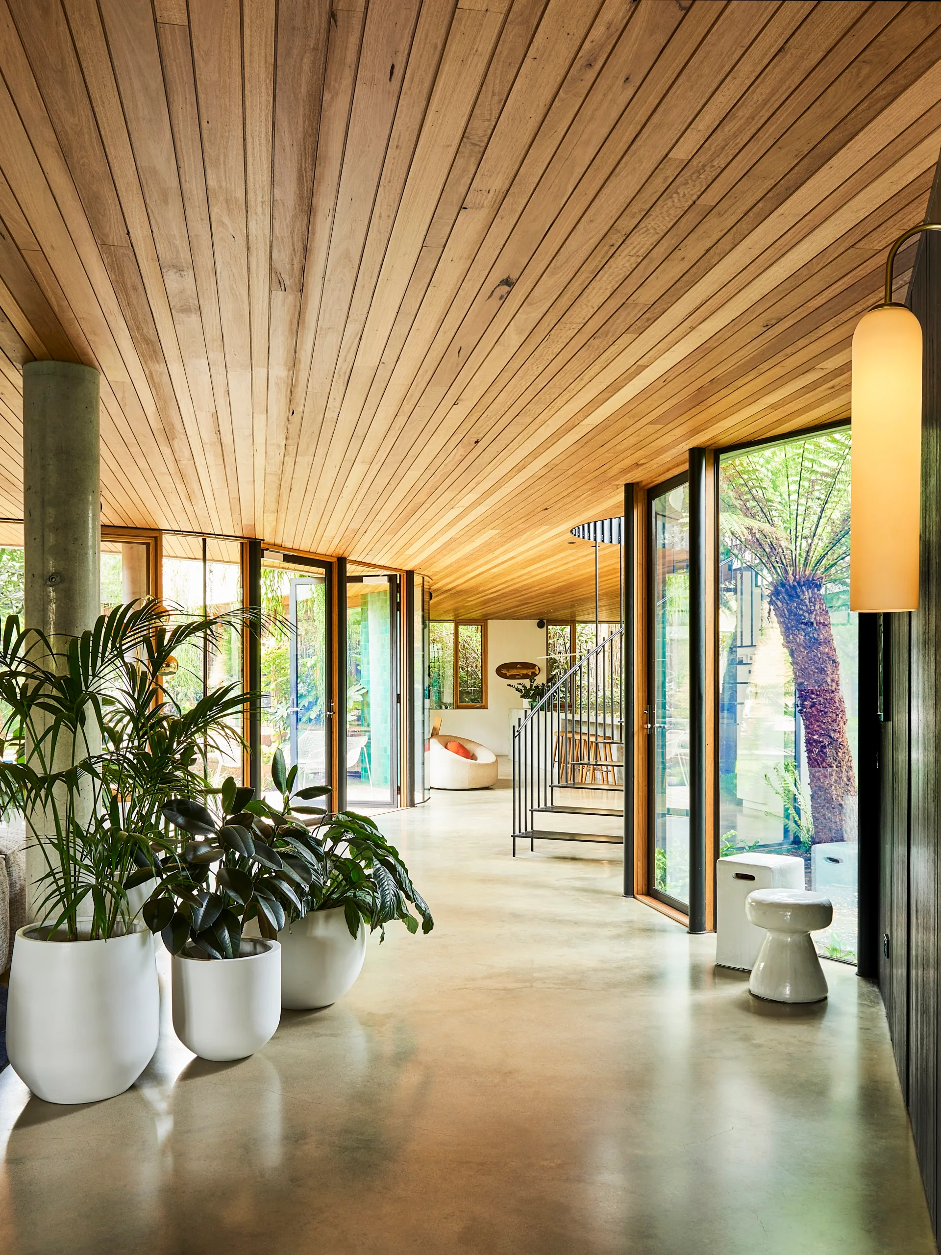 A living area with floor-to-ceiling windows and concrete flooring