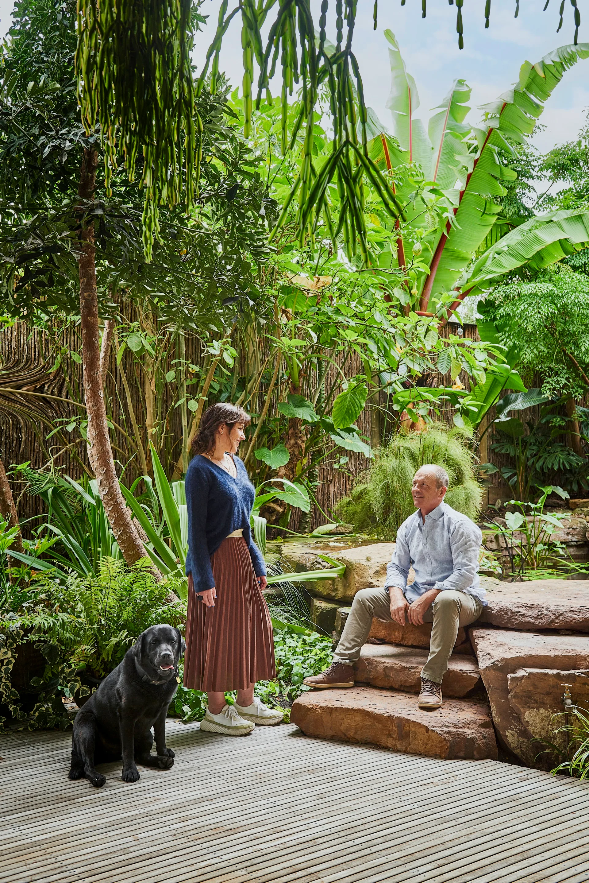 Homeowners and their dog sitting outside in the garden of their Barwon Heads home