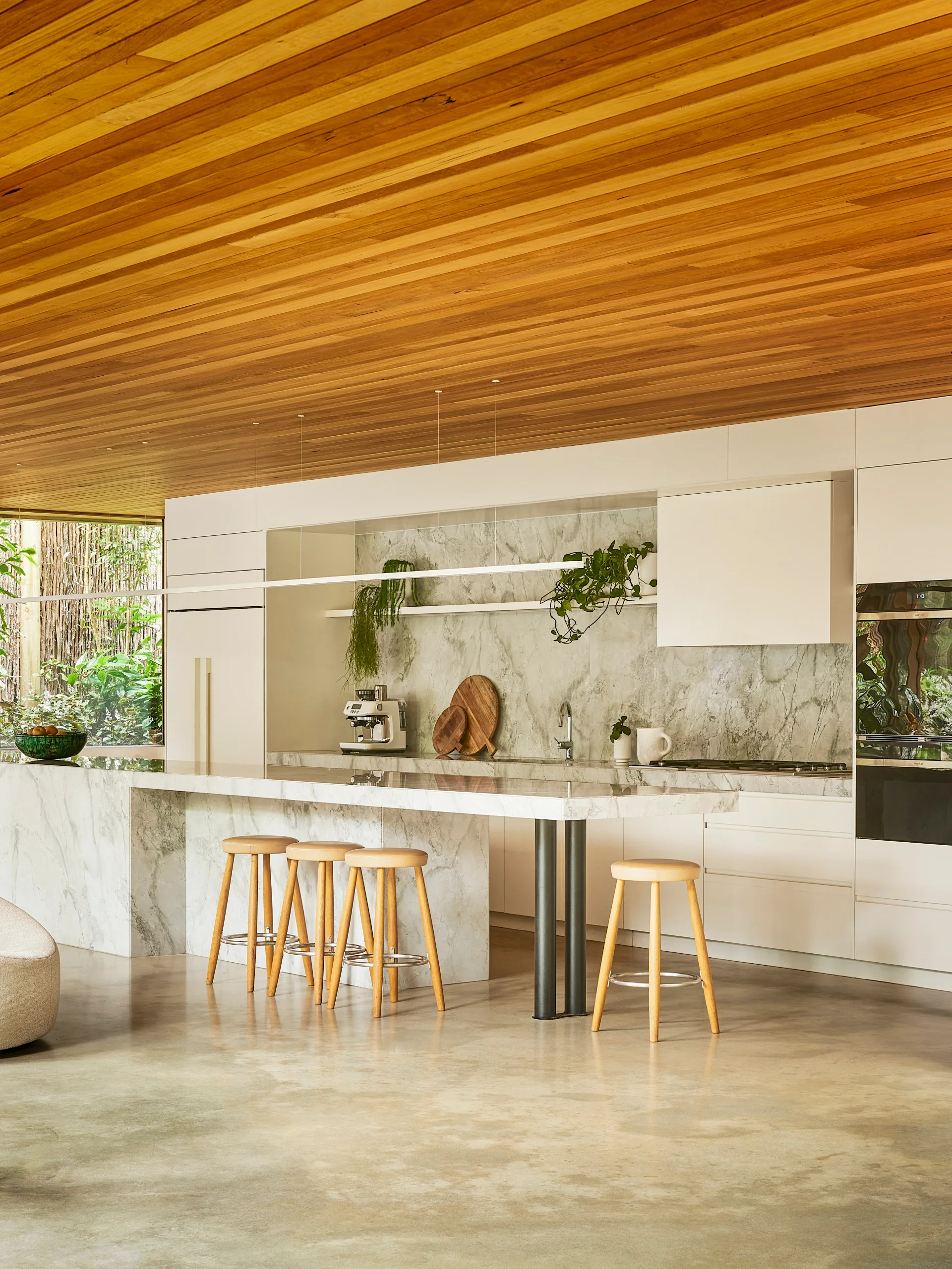 A marble kitchen with a timber ceiling