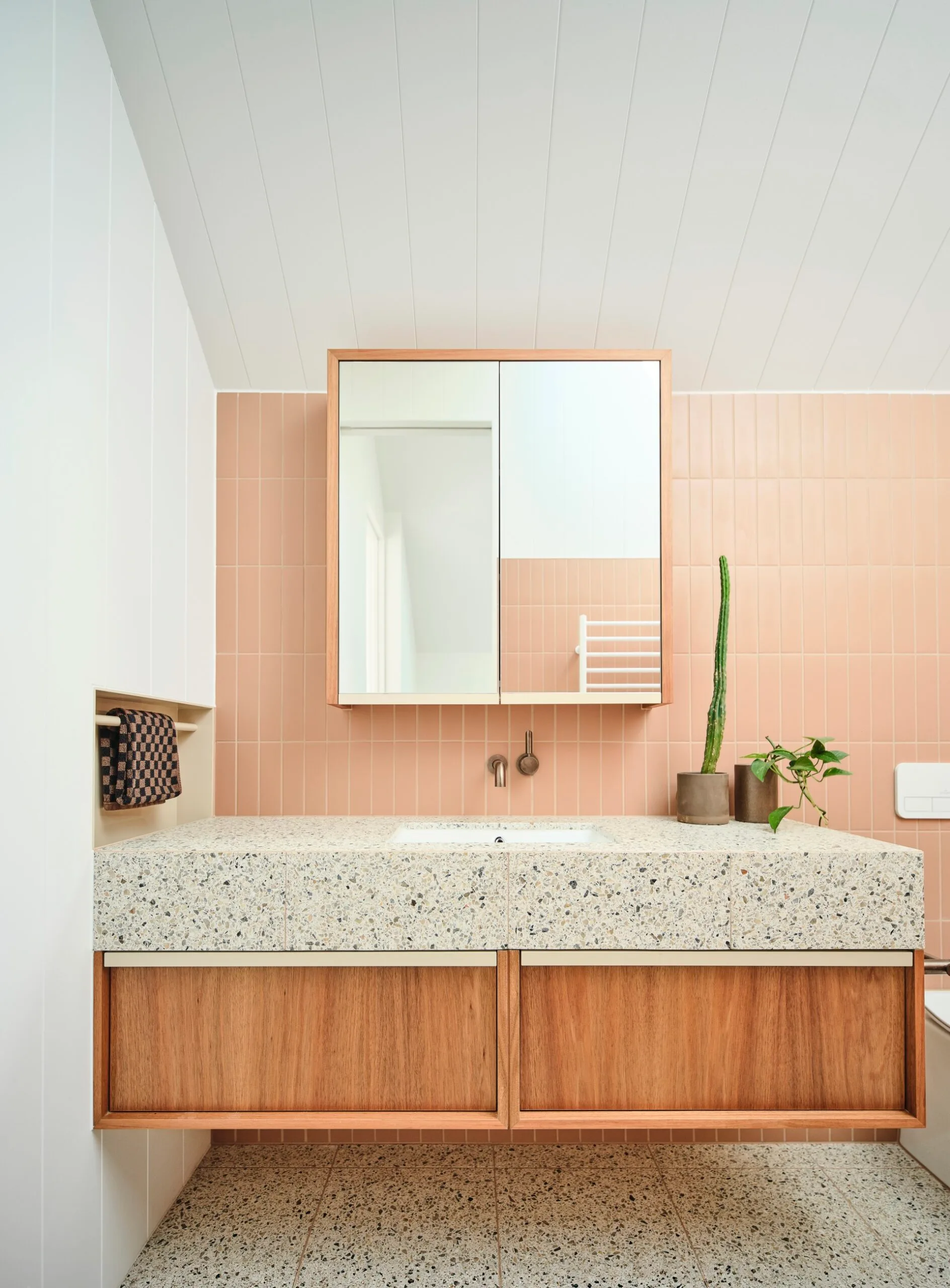 A pink bathroom with stone benchtop