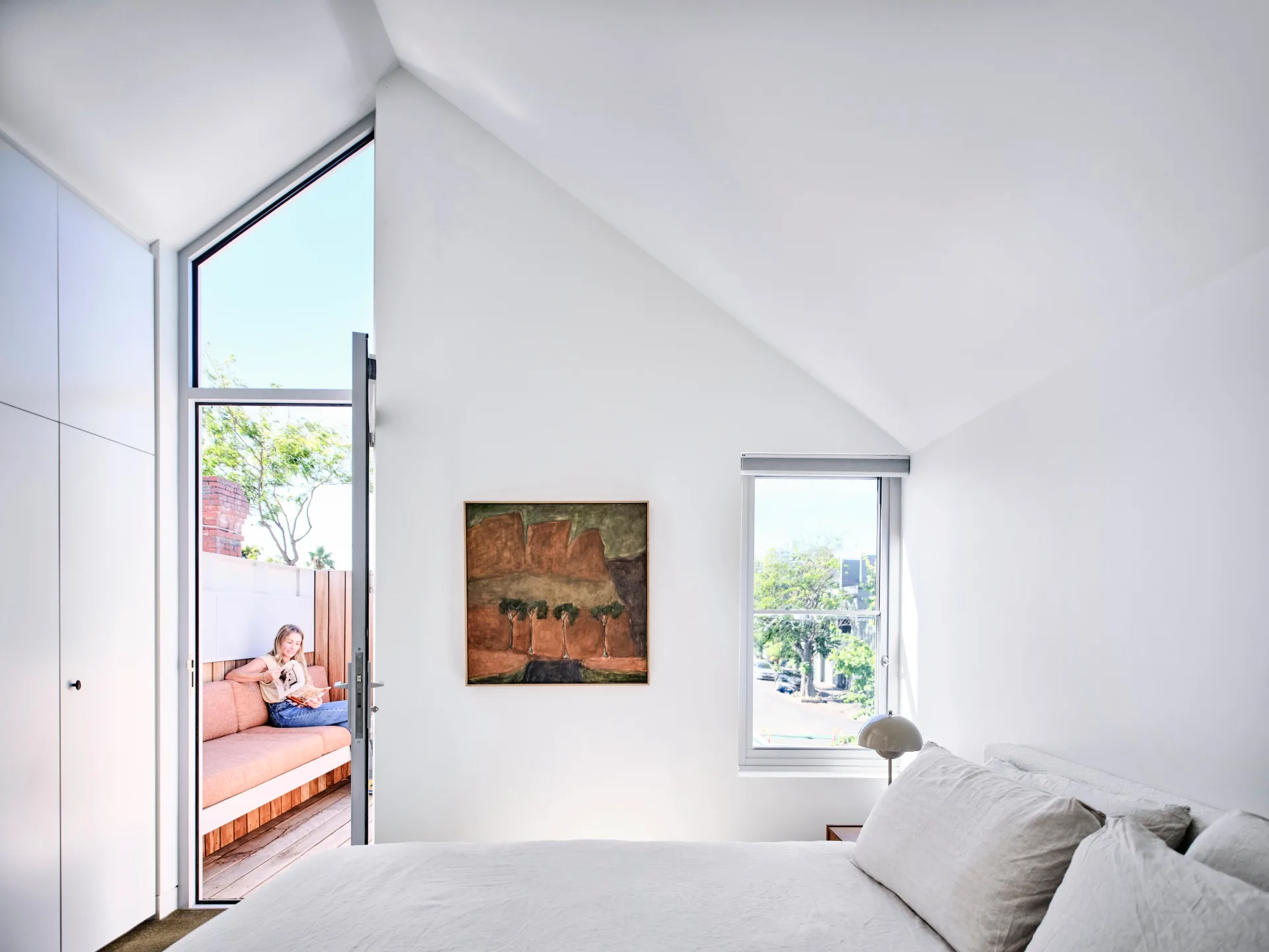 A white bedroom with angular windows