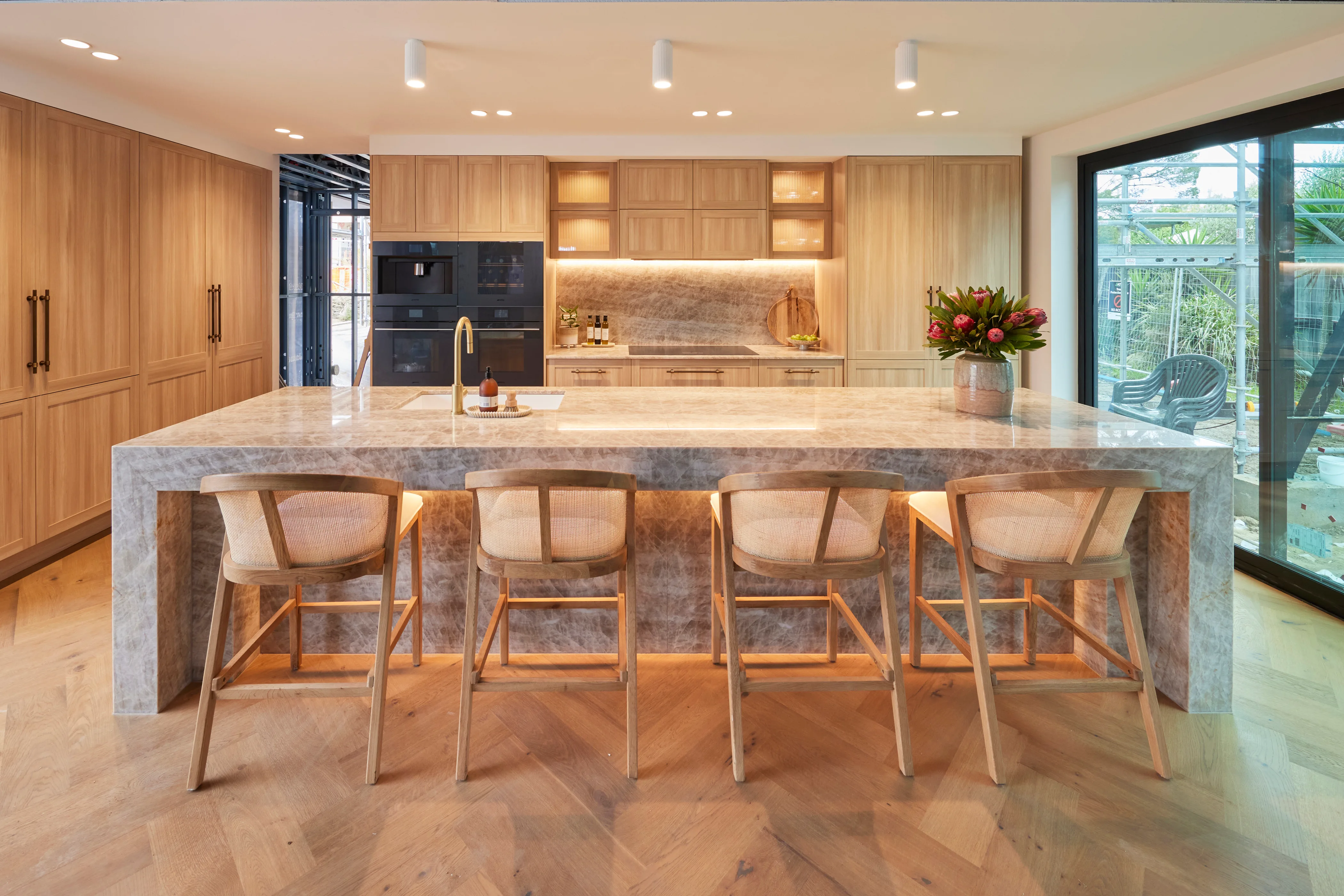 A contemporary kitchen with an oversized marble island bench