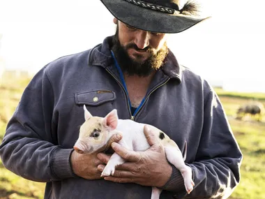 A farmer with a piglet