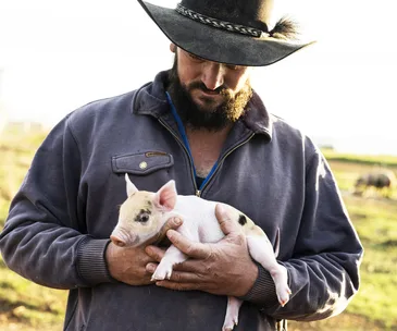 A farmer with a piglet