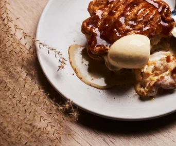 Apple pie on a white plate with vanilla ice cream