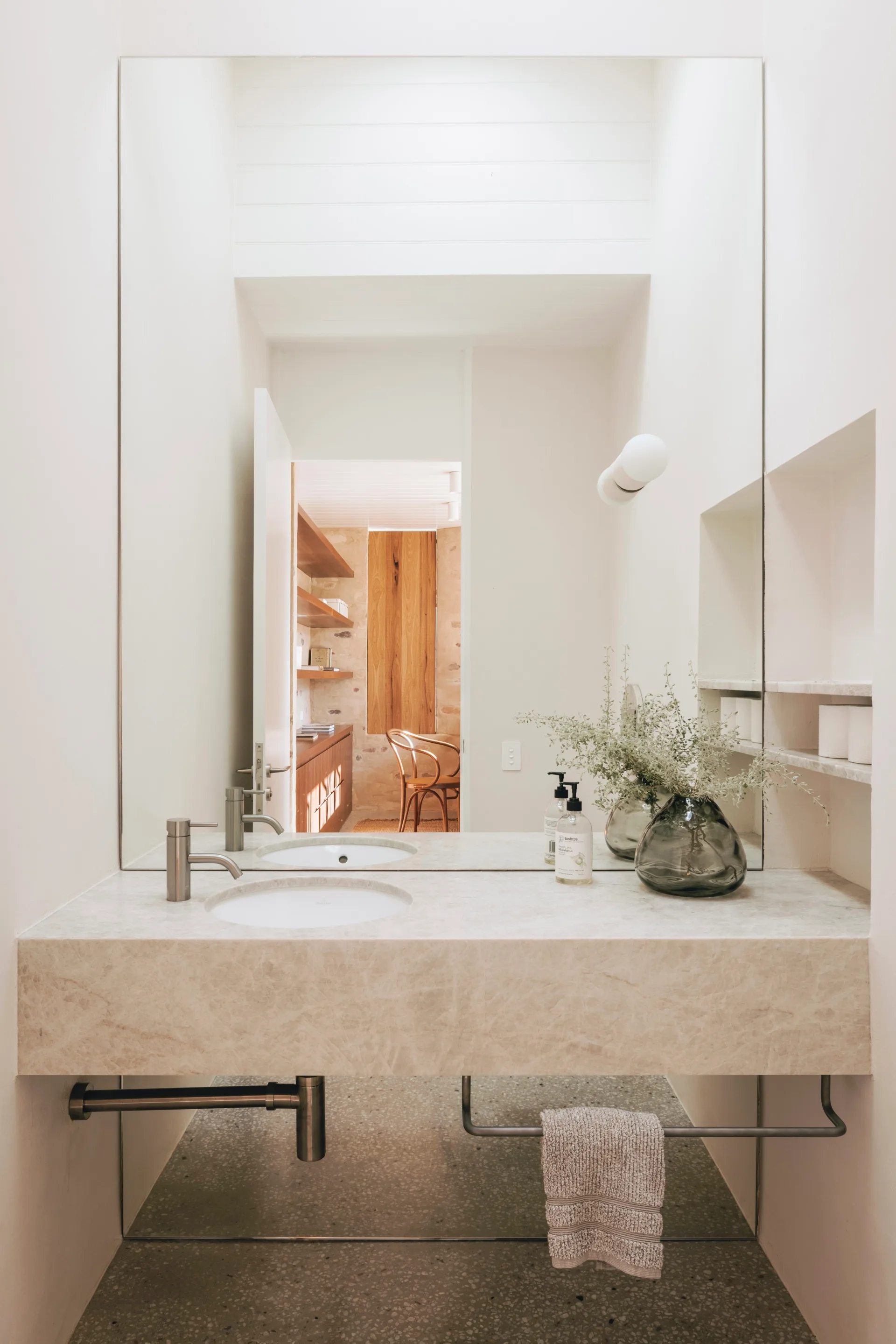 A white powder room with a stone bench