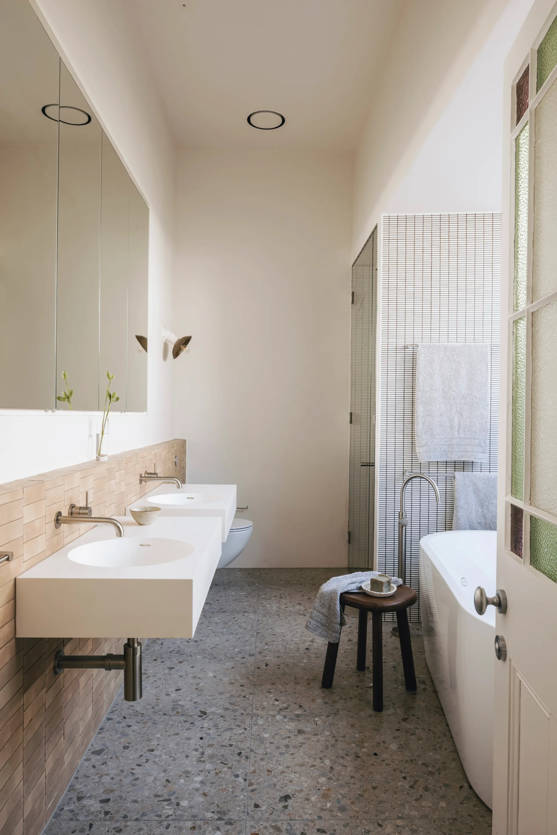 A contemporary bathroom with a freestanding bathtub and rectangular sinks