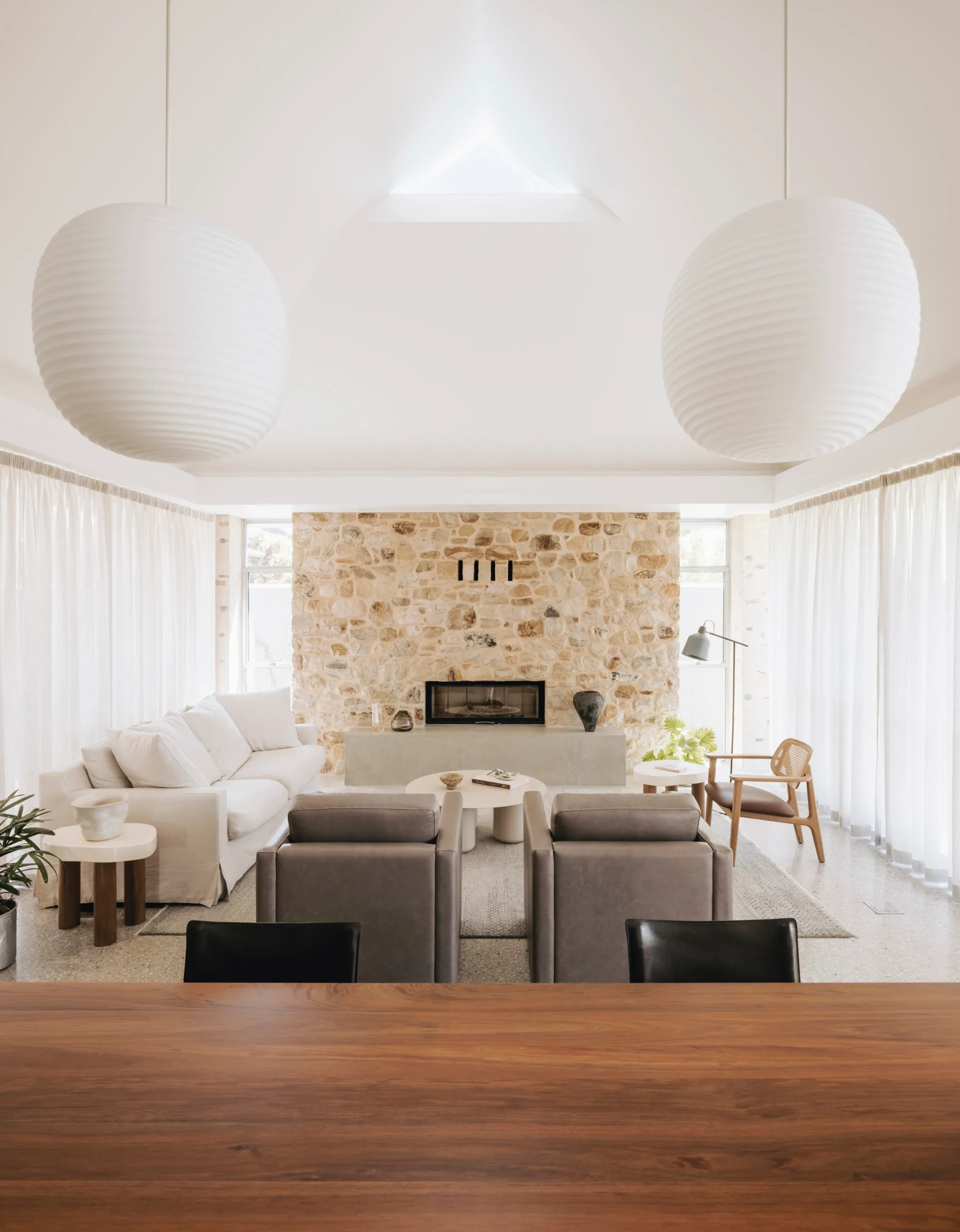 An open plan living area with two large pendant lanterns hanging above