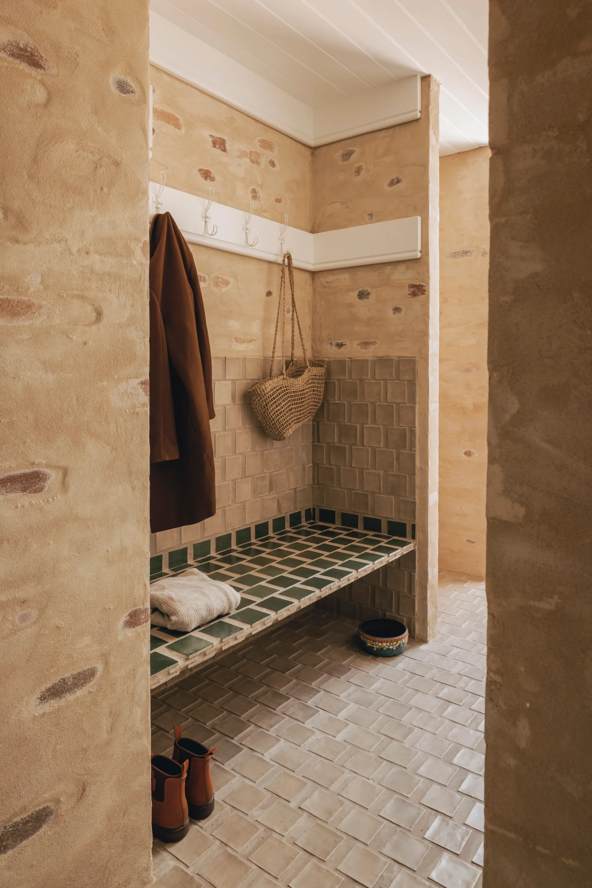 A green tiled-seat in a hallway