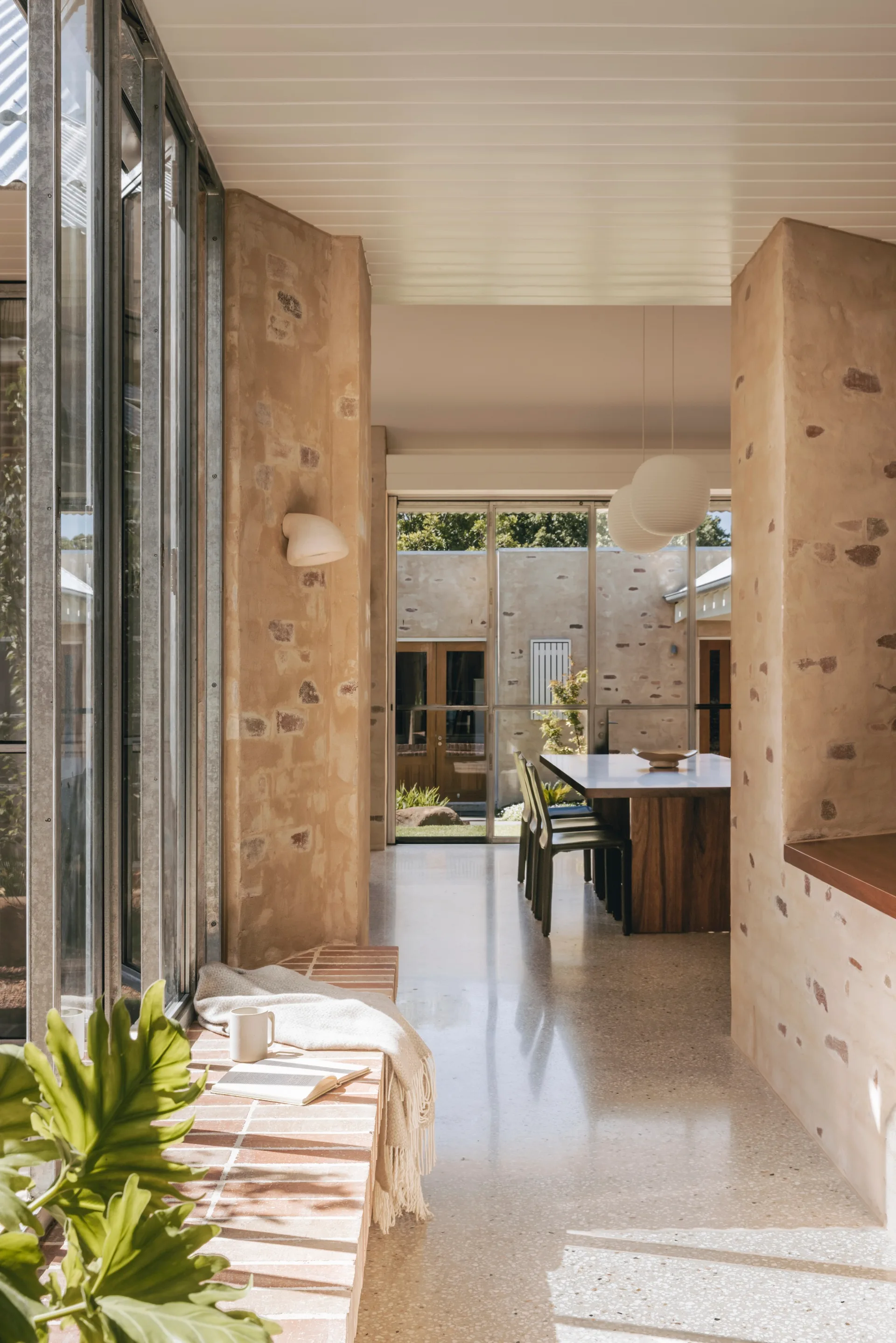 A light-filled hallway leading into an open-plan dining space