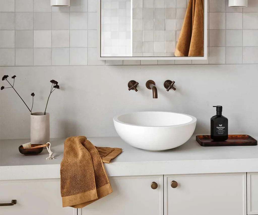 A bathroom styled with Aura Home hand towels and decor