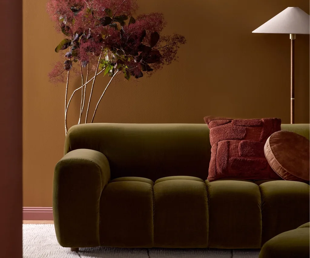 A velvet green sofa and a floor lamp from Freedom