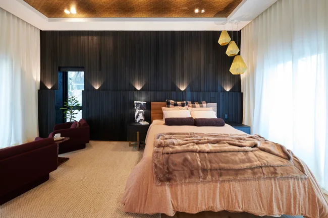 the block 2024 kylie and brad main bedroom with black timber feature wall and gold ceiling