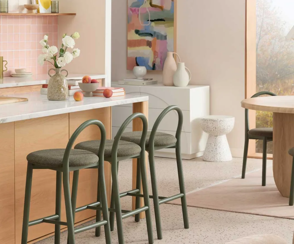 An open-plan kitchen and dining area furnished with green Temple & Webster chairs