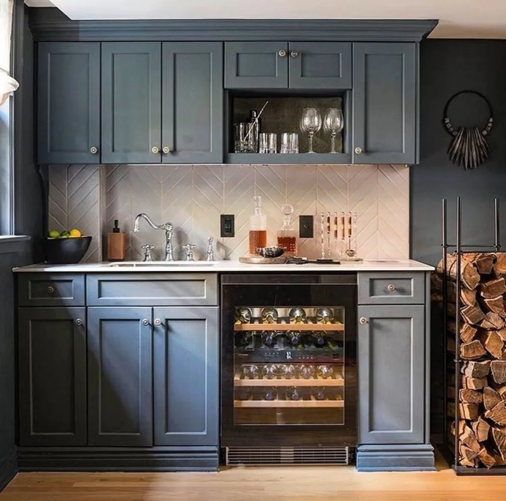 A navy blue kitchen with a built in wine fridge
