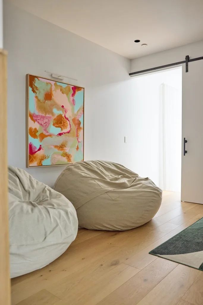 A hallway space with two beige bean bags and a framed artwork